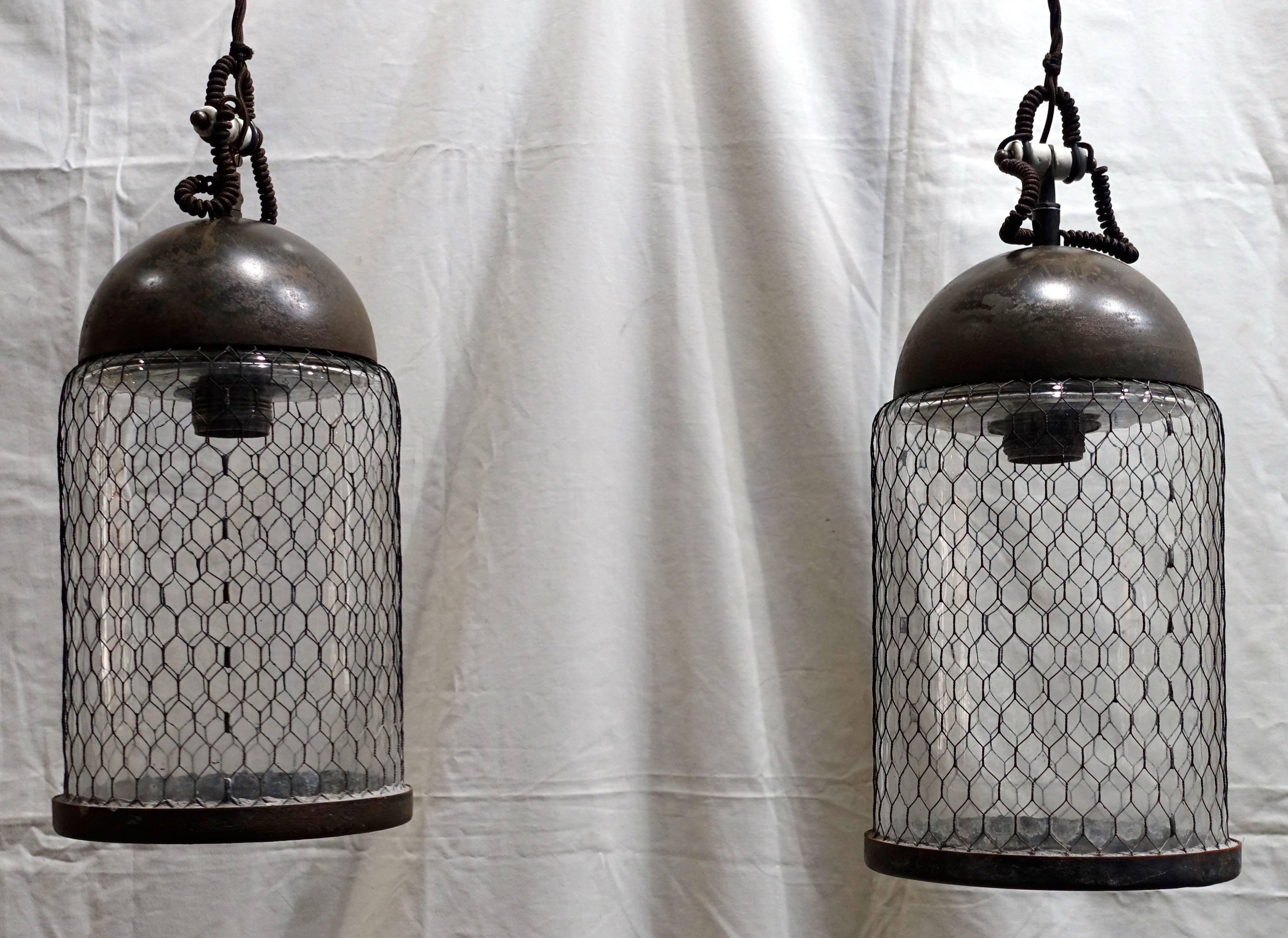 Contemporary Italian pair of elongated brushed pendant lights with cage around glass.
Brushed metal dome.
