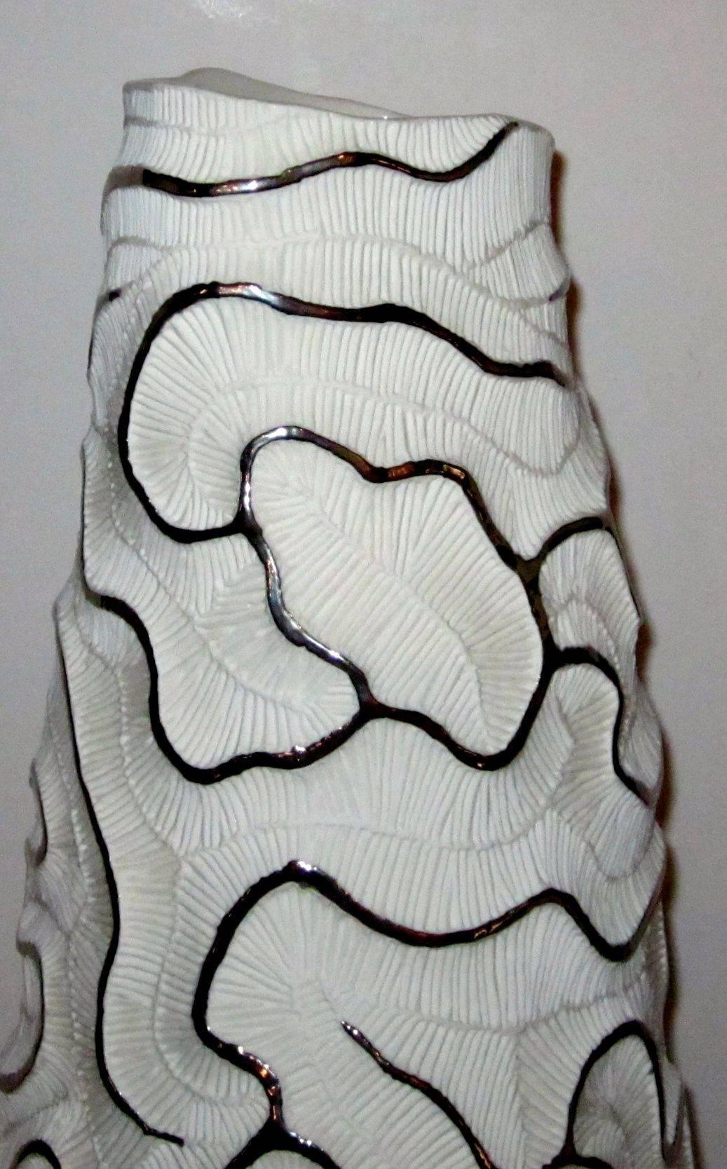 Contemporary Italian handmade tall white porcelain vase with platinum accents.
The organic coral fossil design is outlined with platinum which is the 