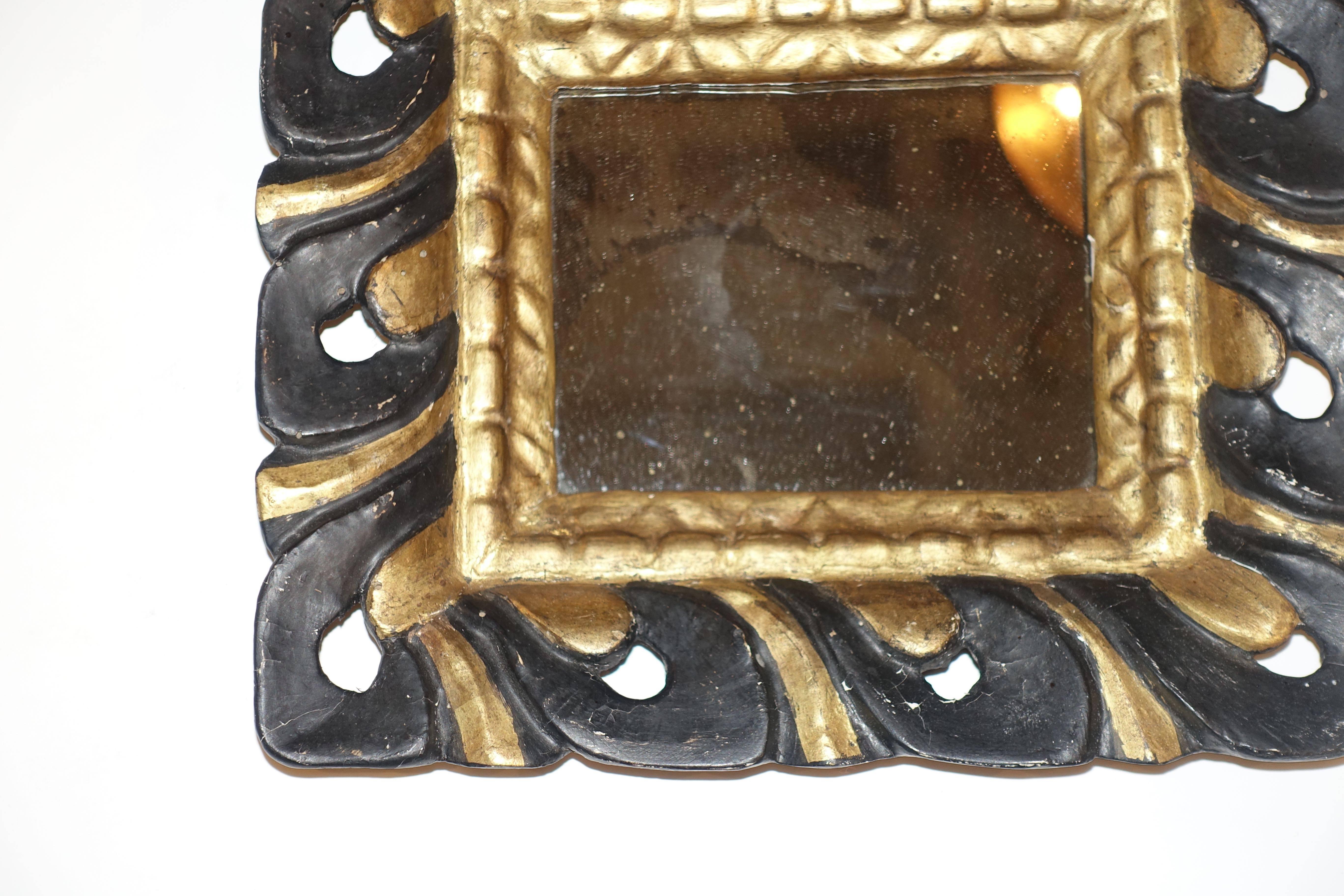 19th century Spanish black and gold carved scalloped wood small frame mirror.