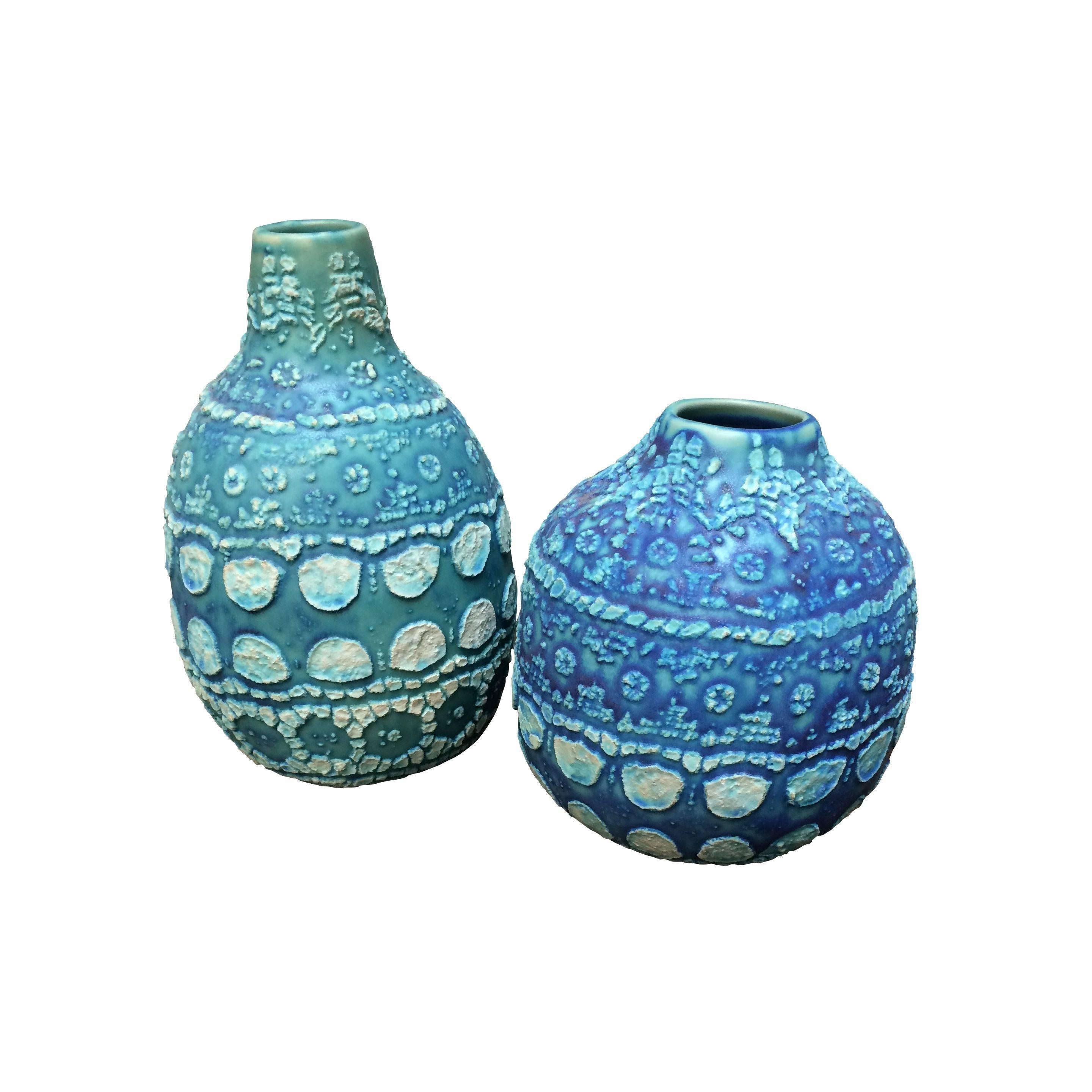 Contemporary washed shades of blue glaze with raised textured abstract motif vase.
Sits well with S4642.
        