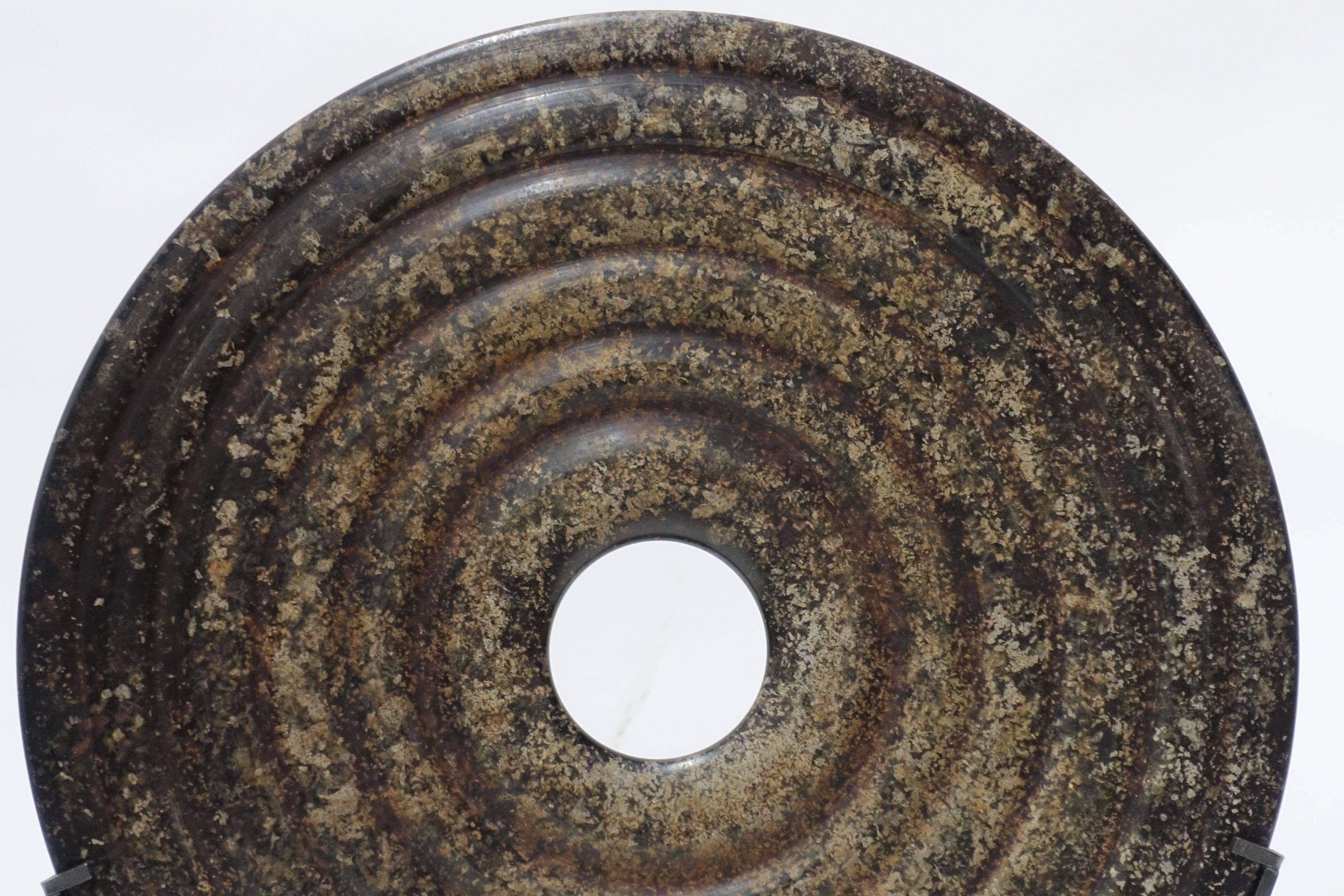 Contemporary Chinese single polished speckled brown stone disc on stand
Ribbed decorative detail.