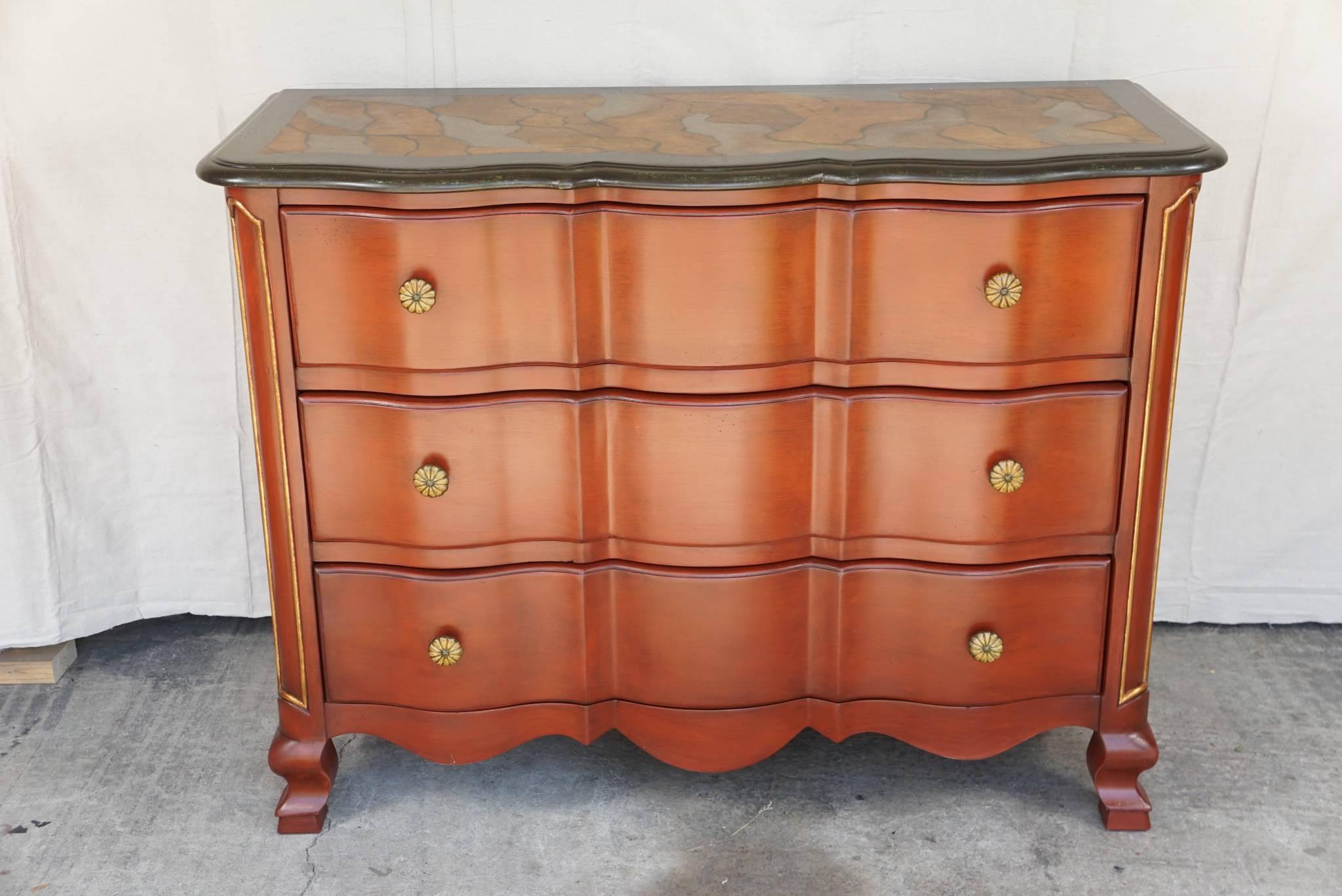 This commode or chest of drawers is of Italian manufacturer and was made approximately 1960. The heavy thick undulating drawer fronts and cabriole legs speak to an old world charm. The surface is painted in a rich Italian Burnt Sienna color ground