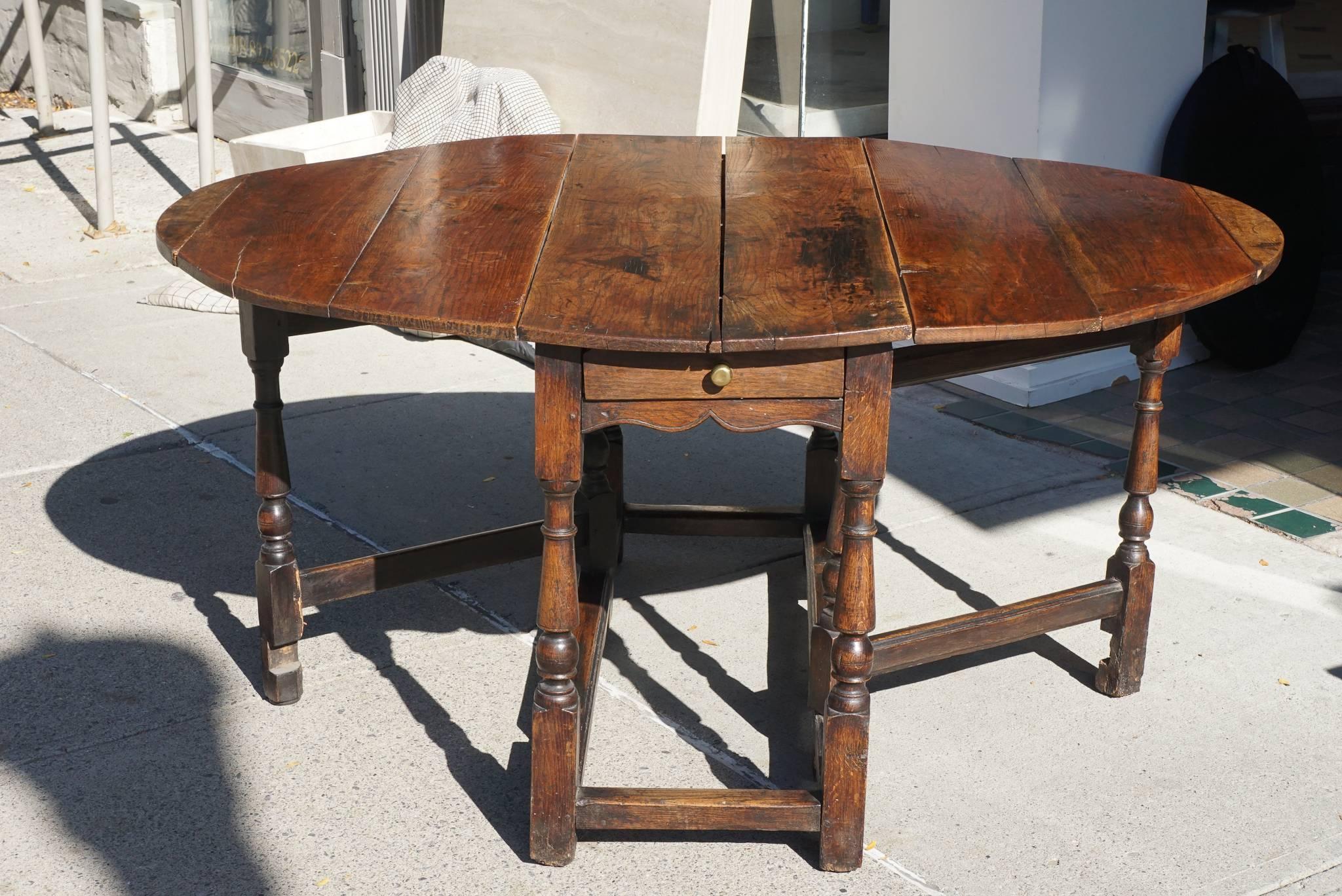 This lovely table crafted from yew wood is of typical gate leg form. This form of furniture was used hard and designed as a work horse in rural settings and the well worn areas and staining to the top are all attributes that add character to the