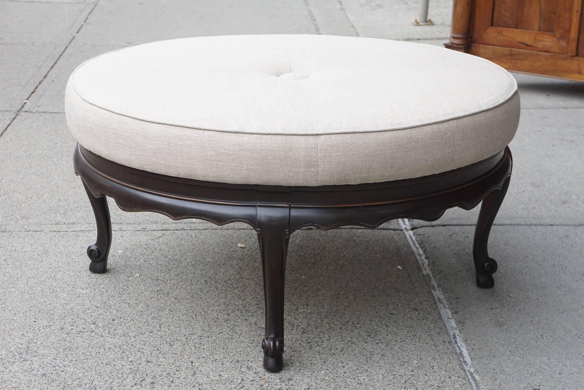 This vintage ottoman is made of carved walnut in a dark Jacobean stain with nice rub thru to the carved areas. The pouf covered in linen is newly upholstered ( we had this done and know that all materials are new) and somewhat harder than a regular