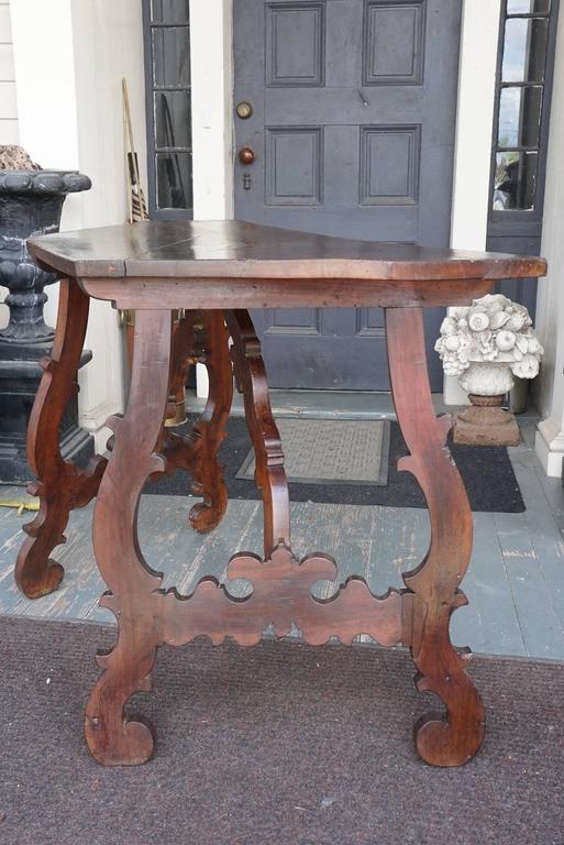 This fine pair of consoles are made in the Tuscan manner and come from Italy. Crafted in the late 18th century from walnut that has by now attained a great color and surface patina over time. The tops are made from a single board of thick heavy
