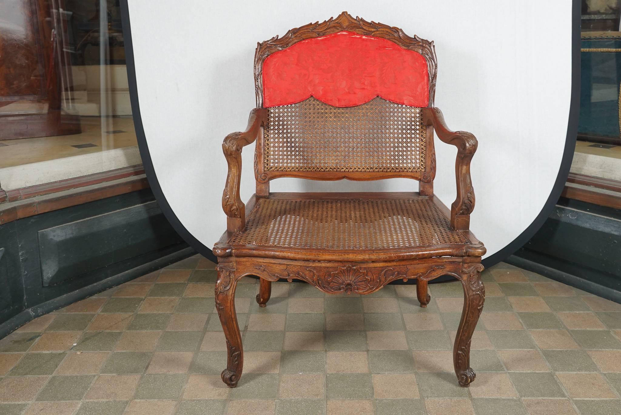 This lovely fine fauteuil a la reine or straight-backed open armchair is carved from beechwood and finished out for light and airy effect in a caned seat and back. The chair formed part of the New York City Home from the estate of Monique Uzielli,