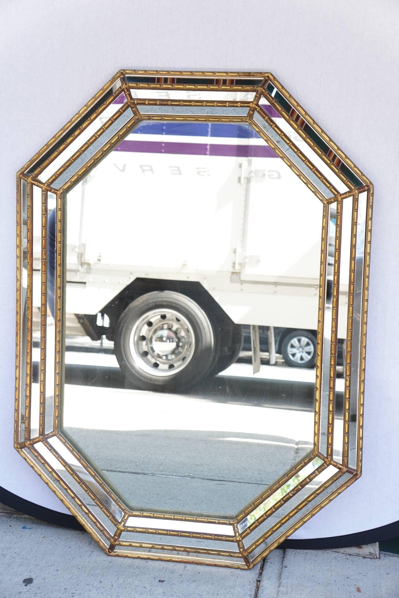 This nice carved wood mirror gilded in a typical old world fashion was made in Italy, circa 1960. Shaped as an elongated octagon the mirror can hang horizontally or as shown vertically. The gilding is good and the multiple. Panels of glass create a