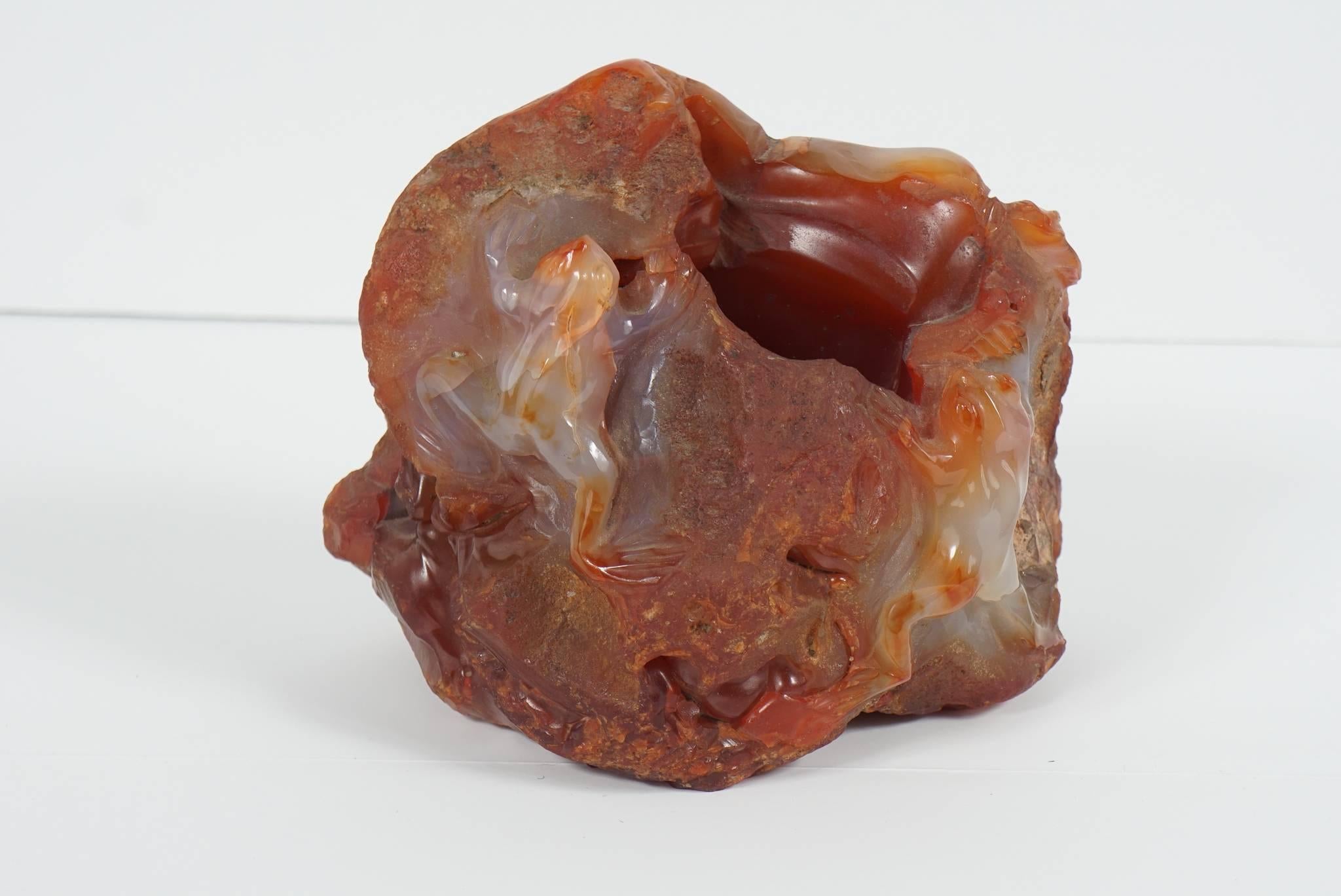 This very interesting scholars object is a naturally shaped bolder of agate with its natural and unpolished surface remaining then enhanced with carving bringing out frogs climbing over the bolder. A well has been done into the bolder making it a