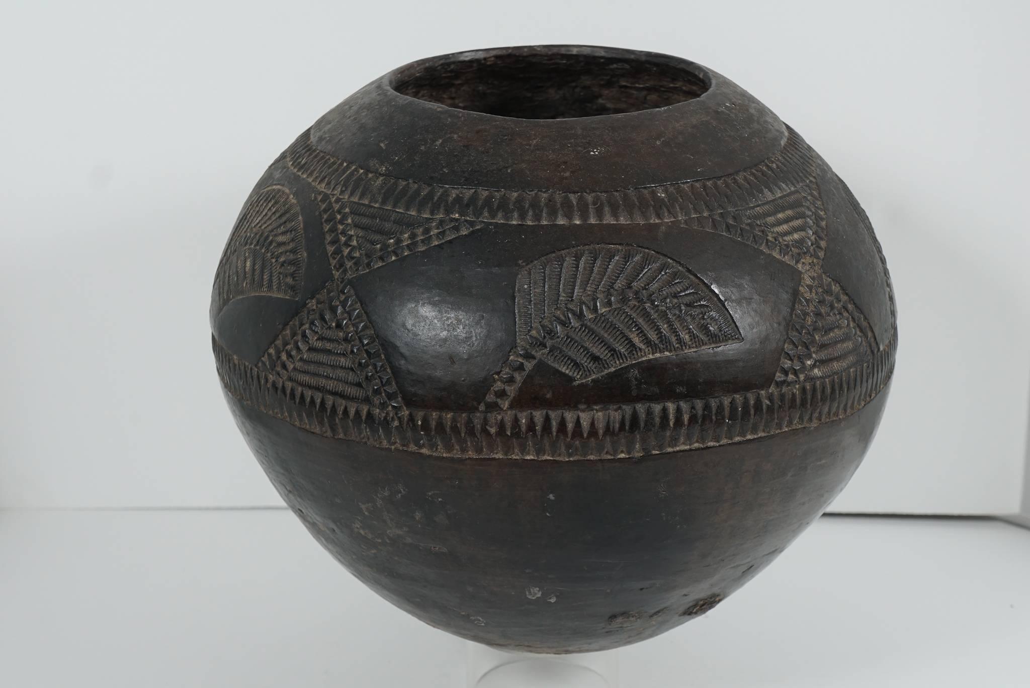 This Ukhamba or beer pot comes from Melmoth South Africa and was made by a member of the Mkhandlwini clan specifically the Masuku family set. Collected in the 1970s but dated to being clan made in the 1960s. Potted as a large enclosed bowl the