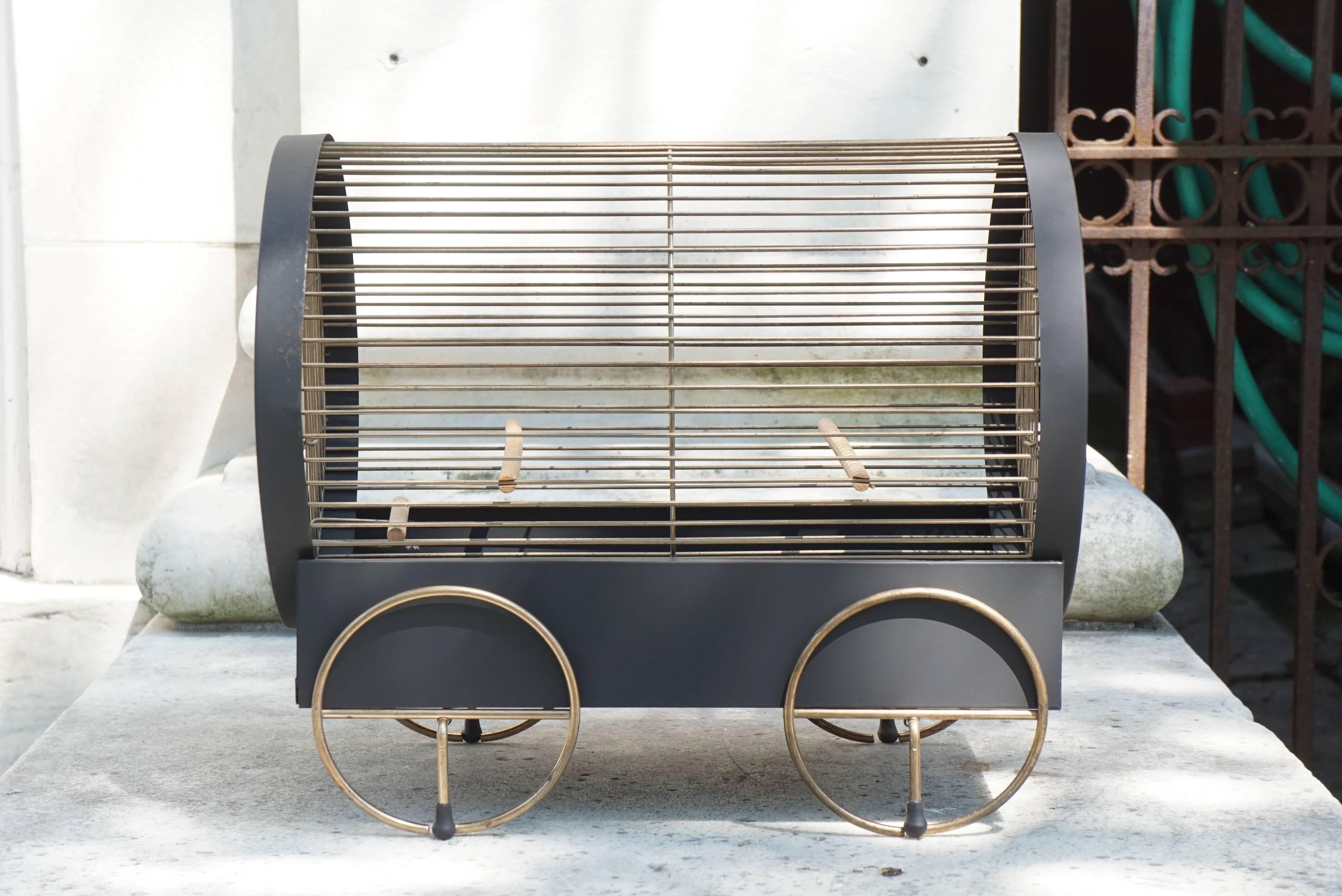 This very fun vintage bird cage for small birds such as parakeets was made in America in the late 1950s. Made from painted steel framing and brass trim the cage is a great decorative accessory with or without a bird. In the form of a covered wagon