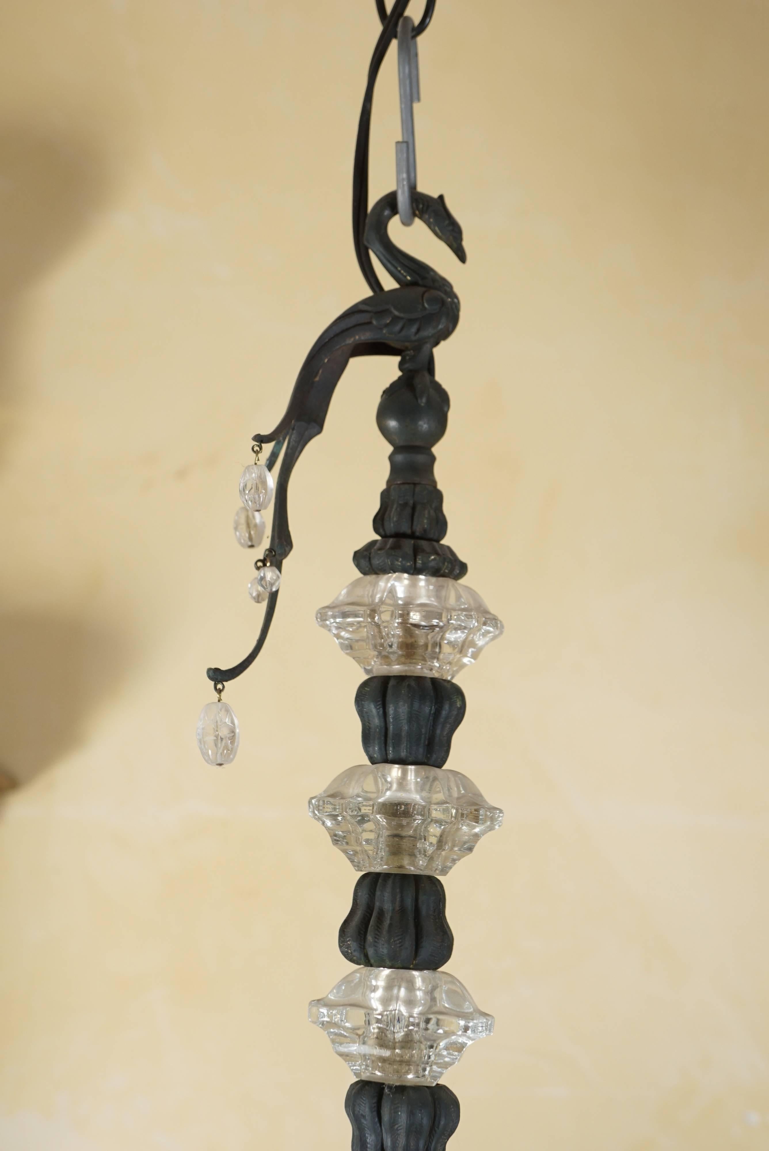 This fine early 20th century light fixture by Baguès was made in France, circa 1930. Created by one of the countries leading lighting and accessories firms from patinated bronze, cut and molded crystal and their signature mix of rock crystal. The