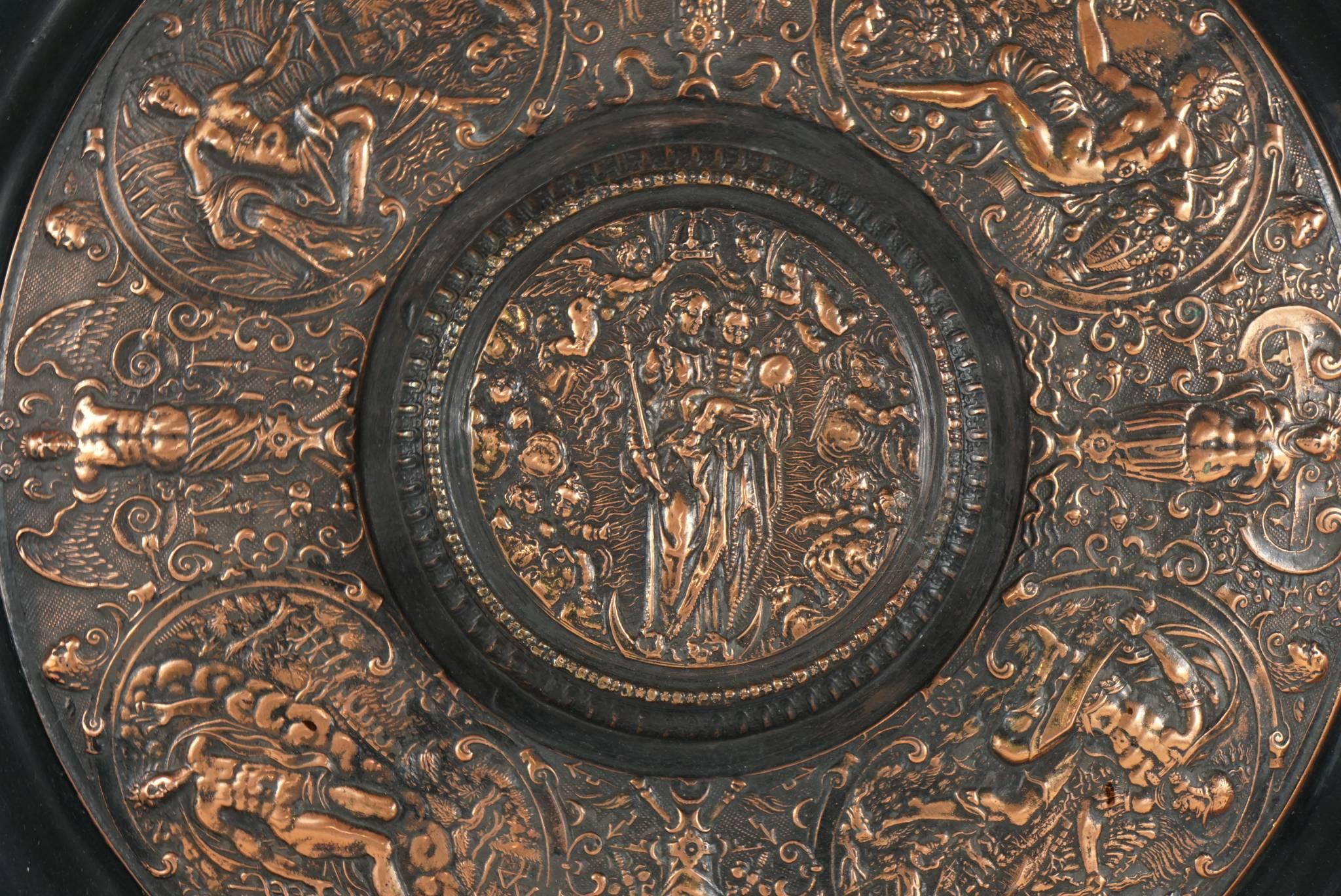 This charger made as an intentional remake of a famous object is fully embossed on the back as such and contains the maker's name. The charger contains many different scenes from antiquity but is centered with a scene from the life of Christ with