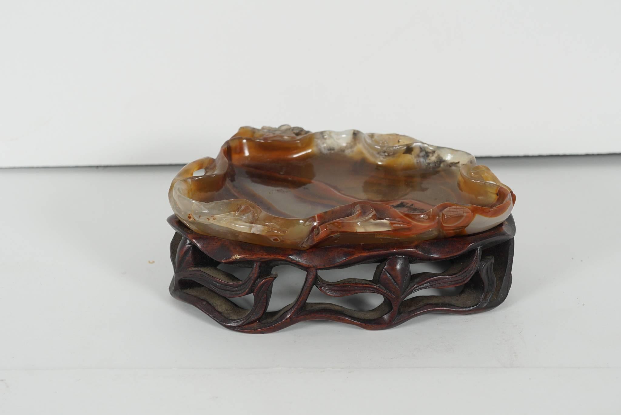From the Estate of C.Z. Guest. This fine small washer carved from naturally banded agate in the form of a lotus leaf is carved top and bottom with natural details and to good effect showing off the many natural colors and striations of the stone.
