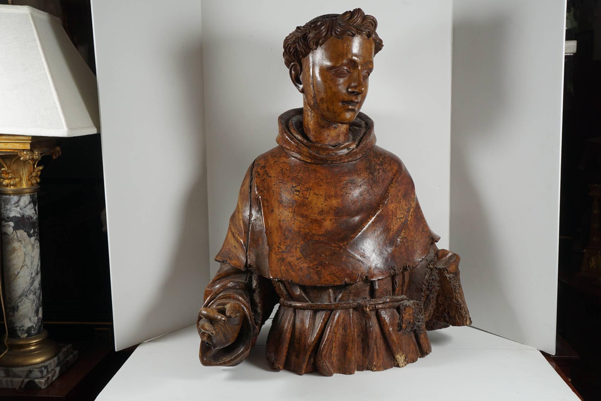 This very fine bust carved in walnut was originally full size and over the years has been cut down to waist height. The color of the wood is rich and glowing. The form sensitive and with much grace and compassion in the facial features. Notice the