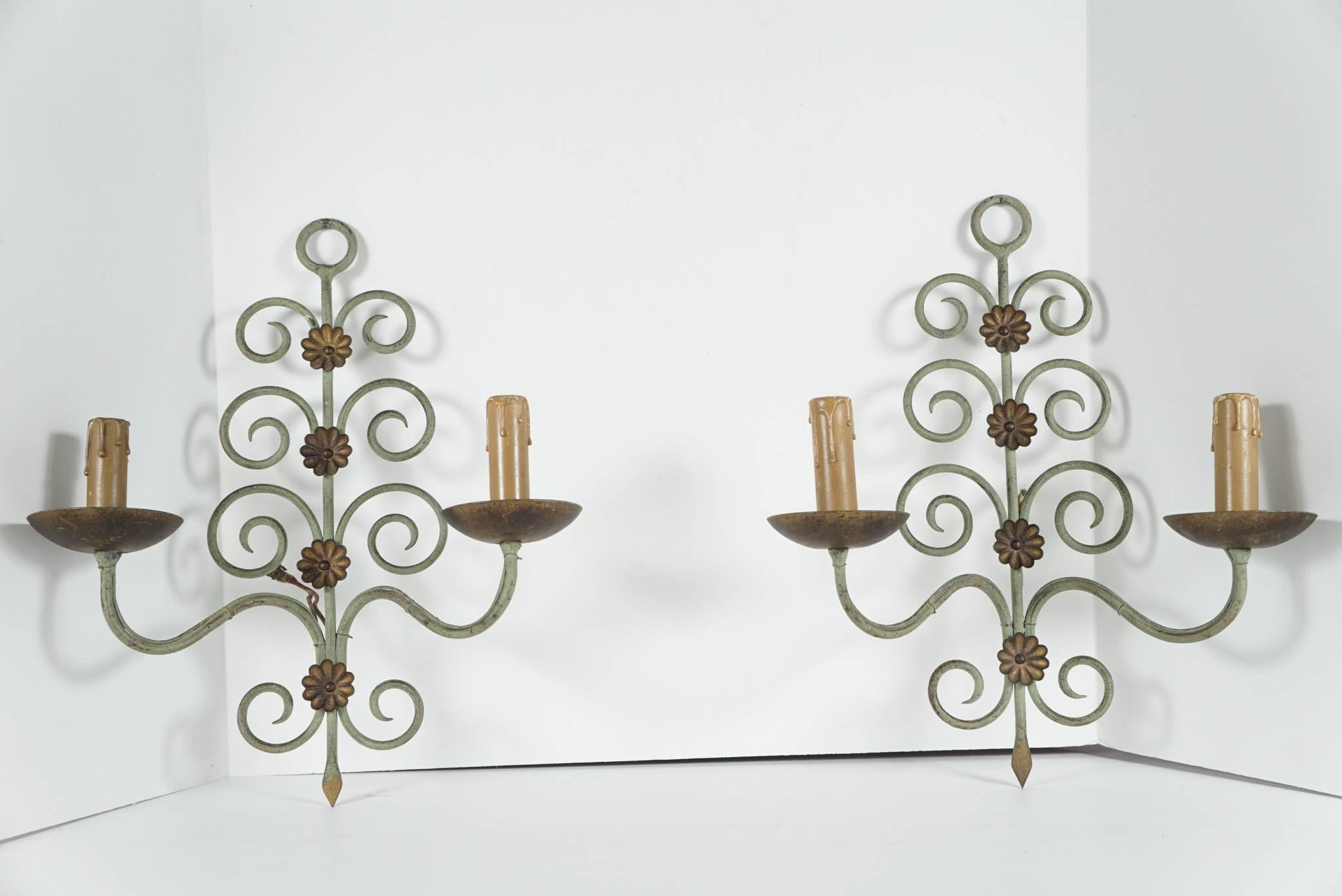 This pair of French Art Moderne two-light scones are made of wrought iron and are painted in a sage green with gold highlights from the 1940s. Totally hand-forged but manufactured to exacting standards in a modern taste they retain original details