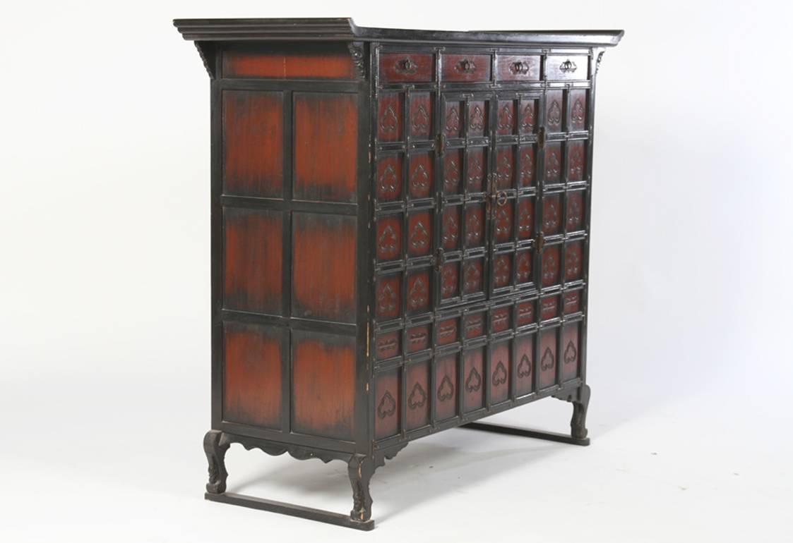 An Asian probably Korean cabinet having a multiple paneled front.
There are two drawers and two central doors raised on shaped legs.