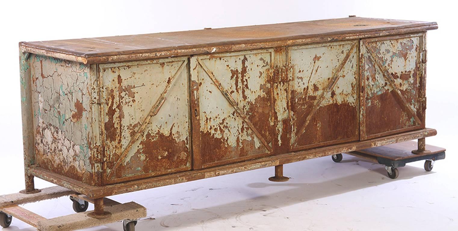 Beautifully surfaced with remnants of original paint, circa 1930.
Large, sturdy and weighty.
A perfect counter with four doors and angled handles.
Surface is wonderful but would require some restoration.