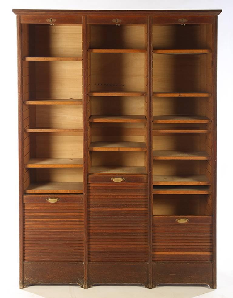 French oak cabinet created, circa 1910 brass pulls and brass locks.
Vertical tambour doors work easily.
18 shelves. Useful for storage or display.