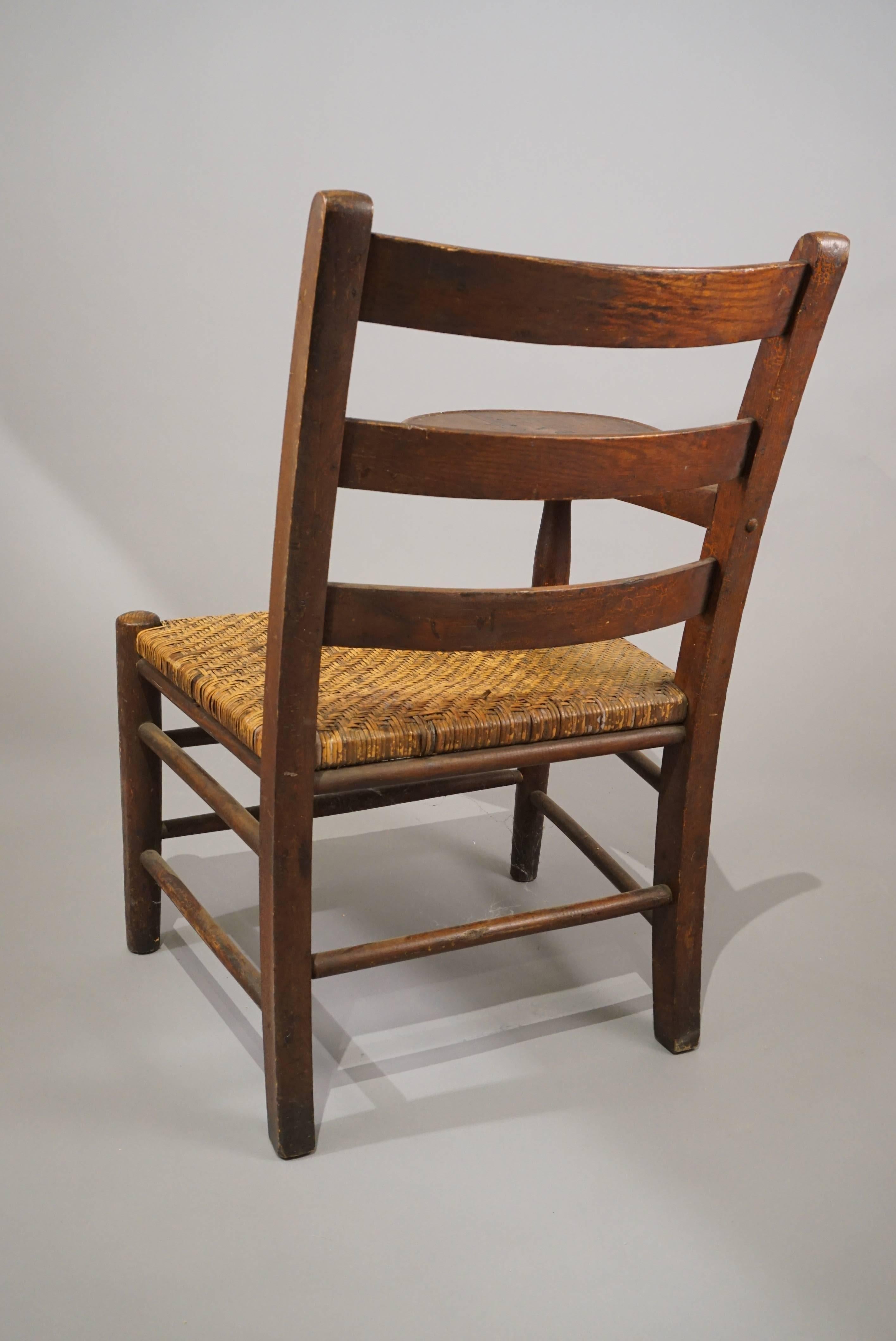 1920s Adirondack chair with a oval writing surface.
Beautiful patina. Original woven rush seat.