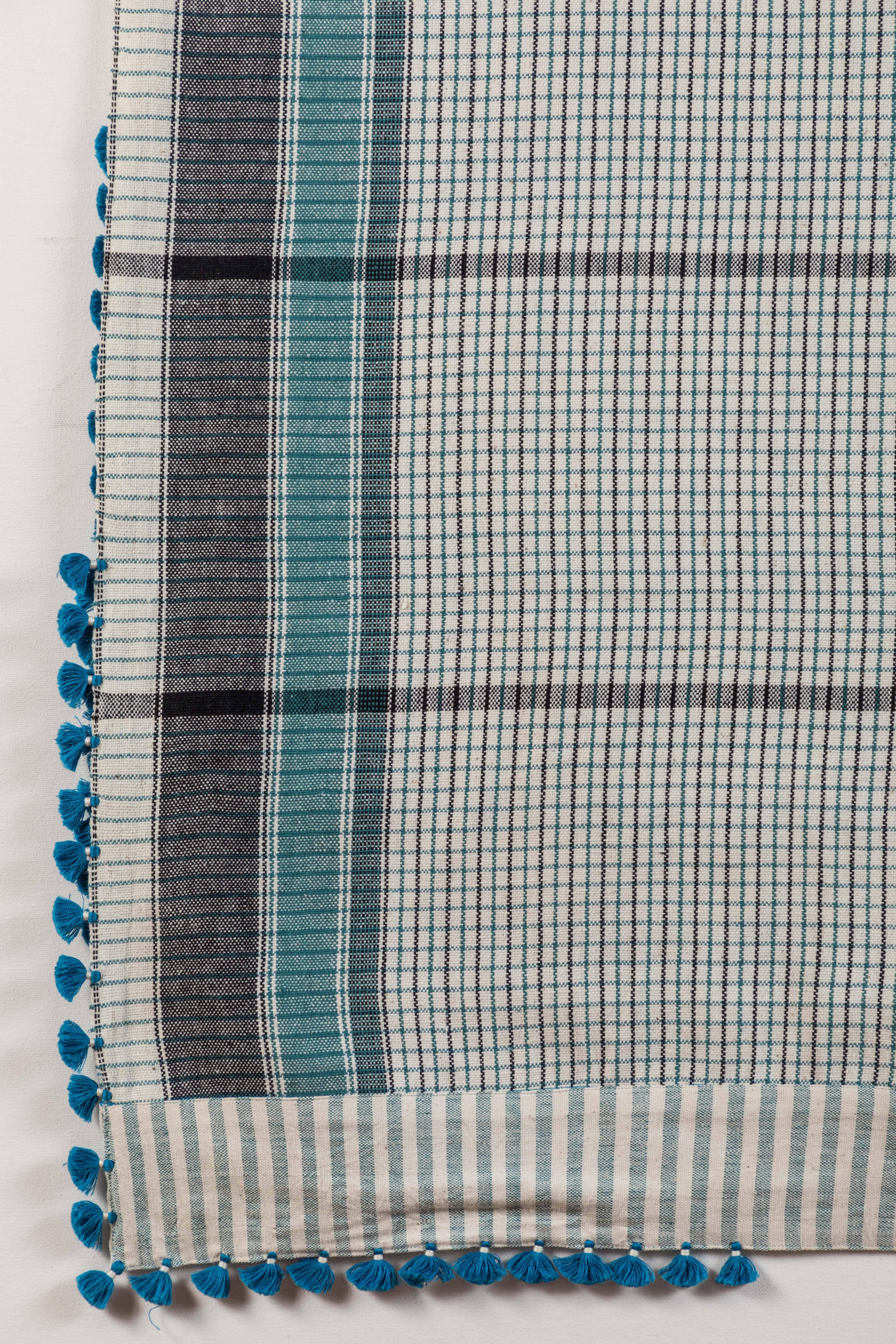 Kala naturally dyed organic cotton from Gujarat, India.   Hand-loomed using traditional Indian textile techniques to produce extra weft woven stripes and plaids.   This turquoise blue, grey, white and black bedcover/throw has added hand-knotted