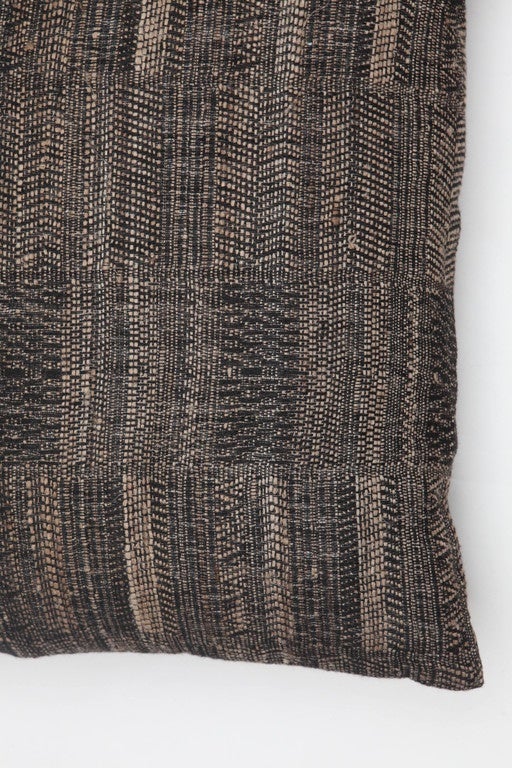 A contemporary line of pillows, throws, bedcovers and yardage handwoven in India on antique Jacquard looms. Handspun wool, cotton, linen, and raw silk give the textiles an appealing uneven quality.

This wool and raw tussar silk pillow has a black