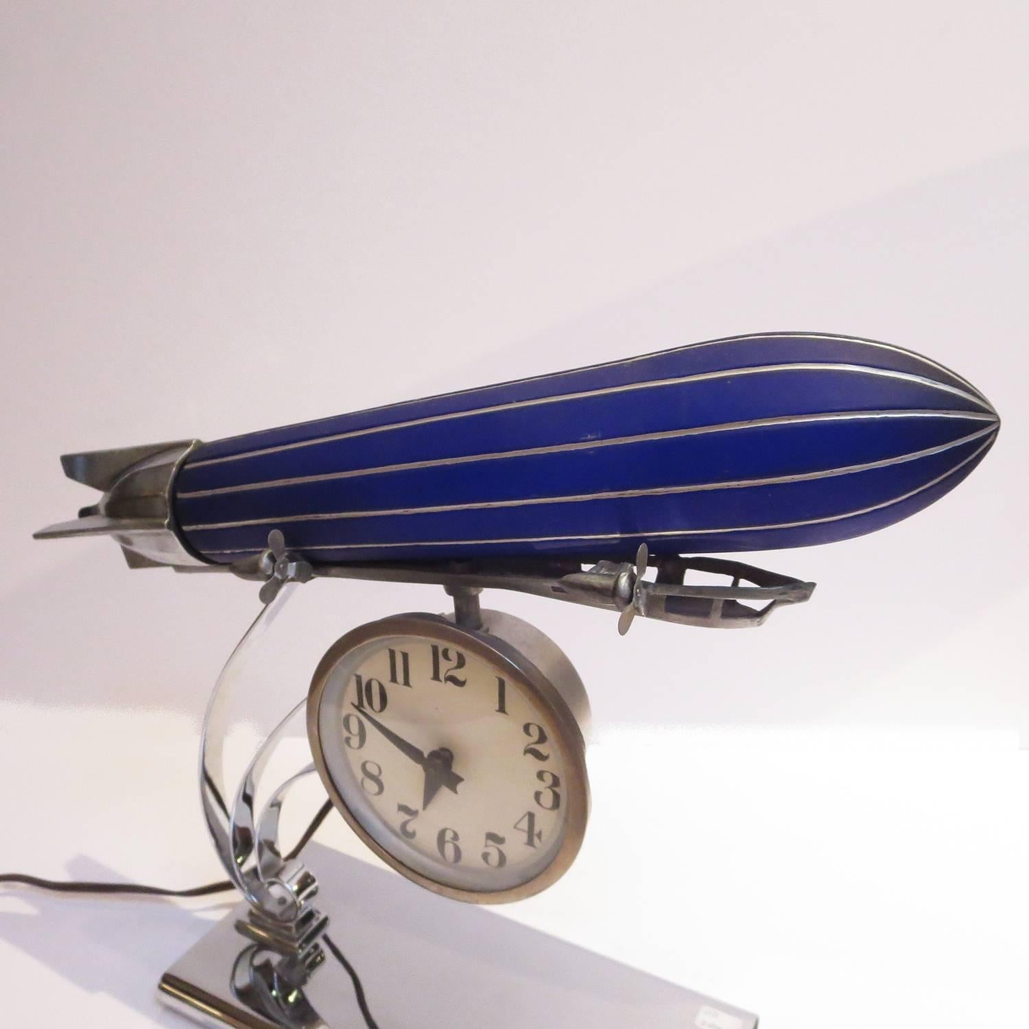 These rarely ever show up on the market for sale. The company made a more common airplane lamp with a blue glass body and chrome wings, which has also been reproduced. The zeppelin, or blimp version, were only made in the 1930's in very small