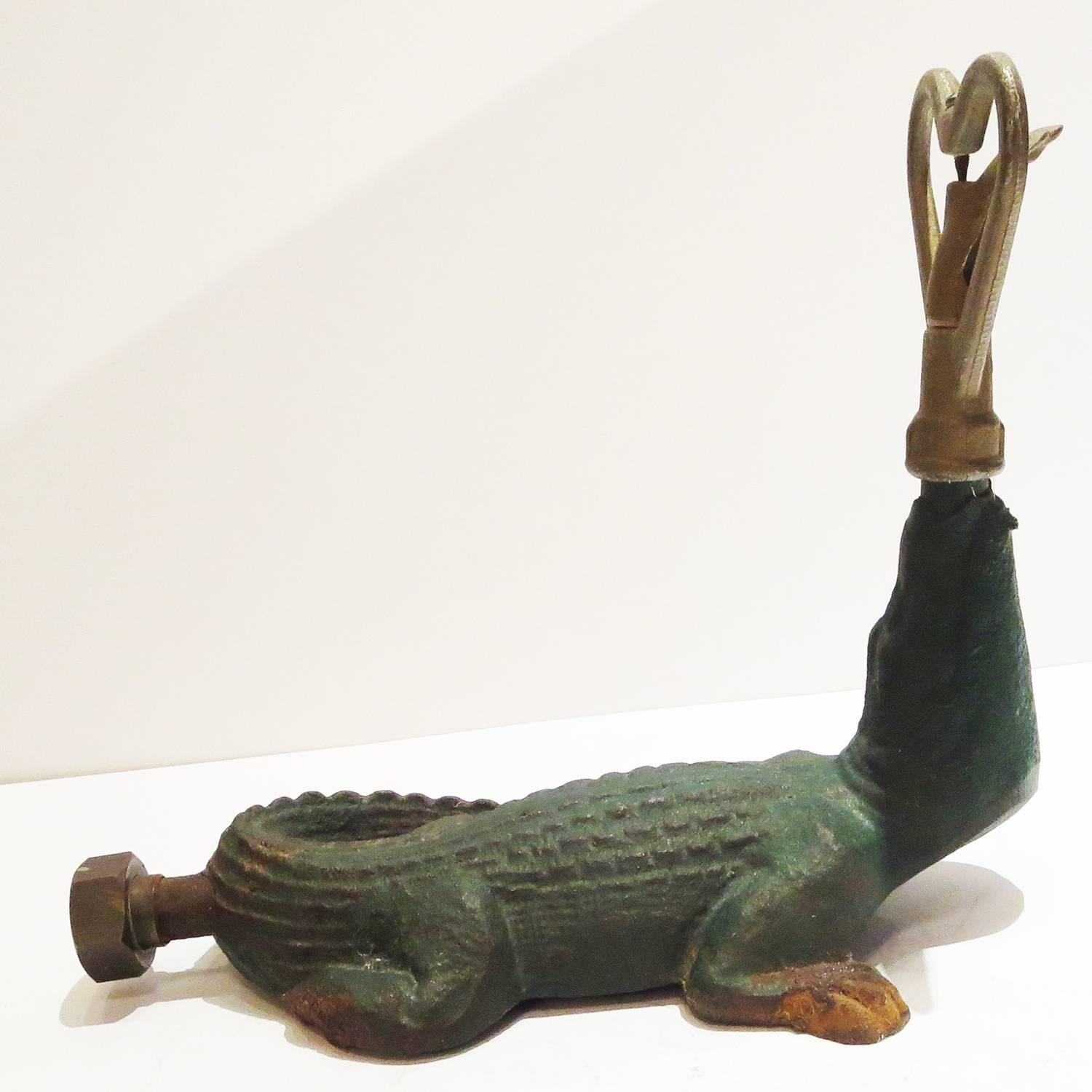 This charming little alligator sits on the lawn, doing all your watering so you can lay back in the shade! The cast iron body has nice original paint, and the revolving sprinkler unit is painted iron.. A hose threads into the tail end of the