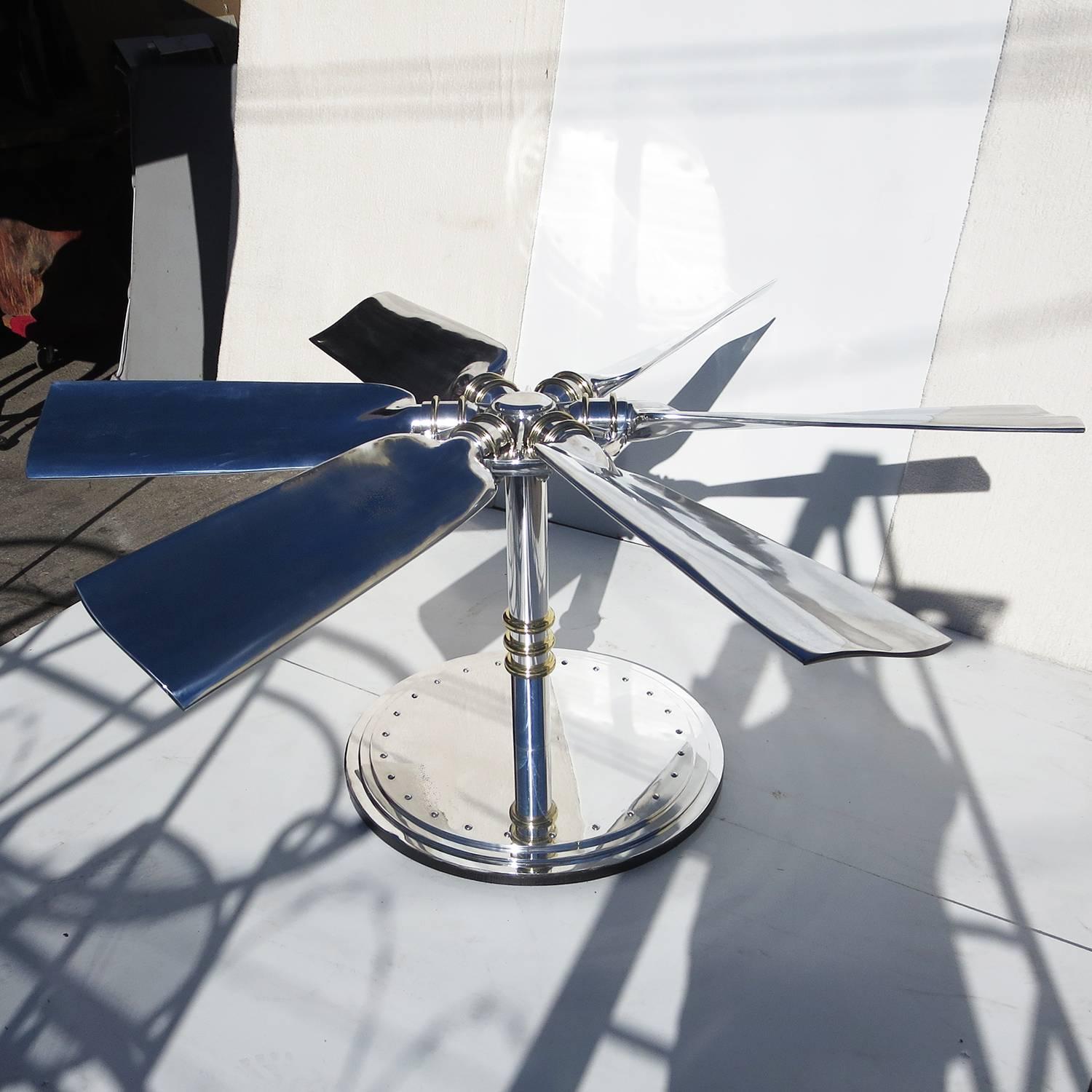 A six bladed propeller was the genesis of this incredible table. We designed and created the base of highly polished aluminum, with brass accents. The propeller blades are 