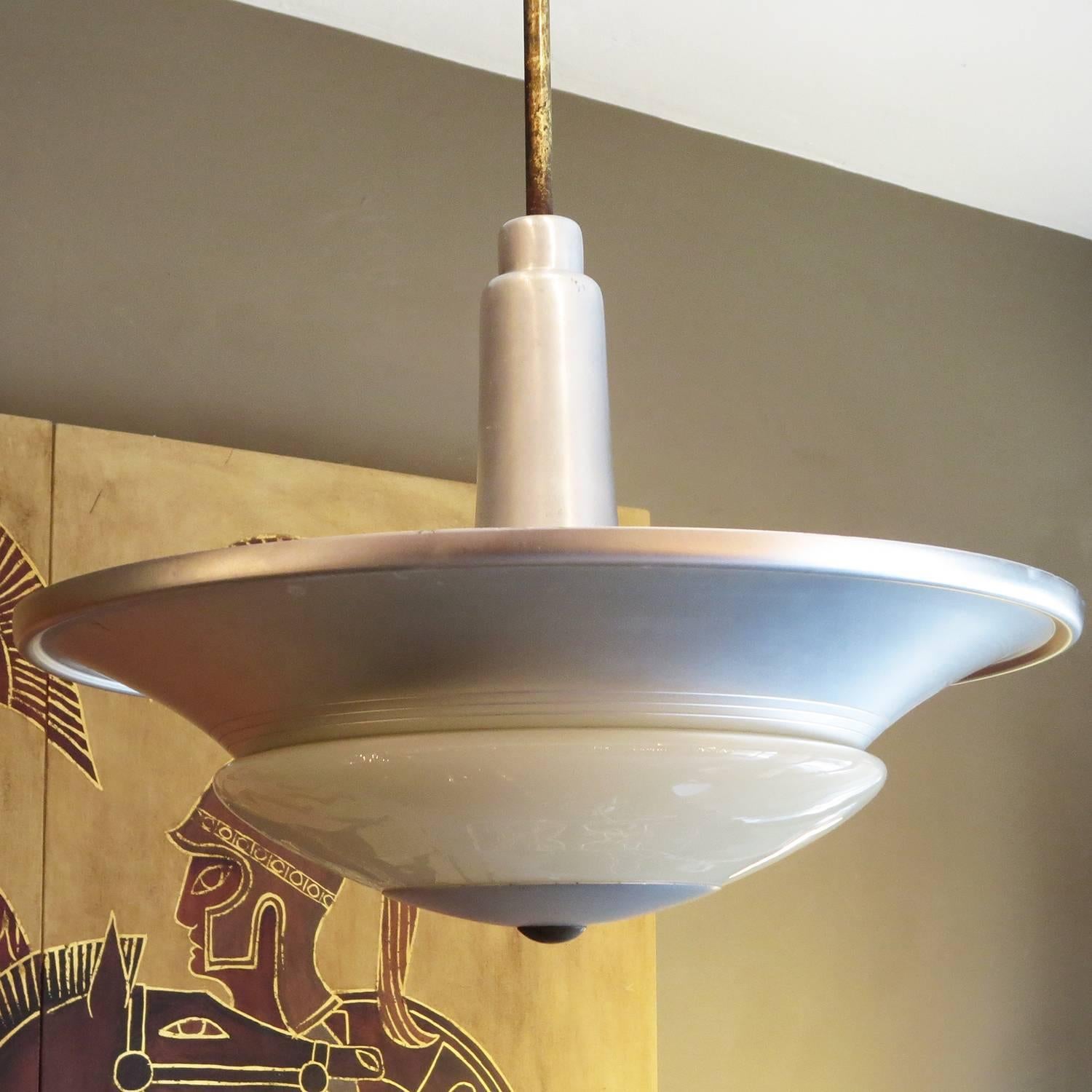 These stylish fixtures were the height of modern when introduced in the early 1930s by Westinghouse lighting. The bodies were finished in a satin aluminum, highlighted by a custard glass shade. A single 