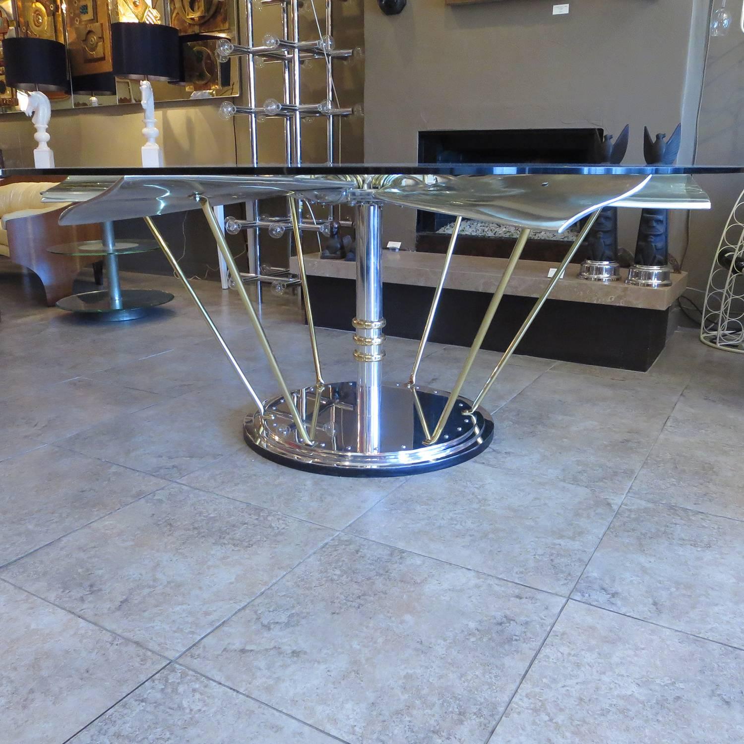 A six bladed propeller was the genesis of this incredible table. We designed and created the base of highly polished aluminum, with brass accents. The propeller blades are bolted in with brass U bolts, over a polished aluminum sleeve. The blades are