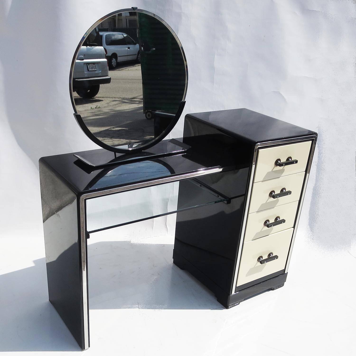 This wonderful and stylized set was designed by famed Industrial designer Norman Bel Geddes for the Simmons Furniture Company in 1934. The set is complete, consisting of the dressing table, a matching bench and tabletop mirror. All pieces are
