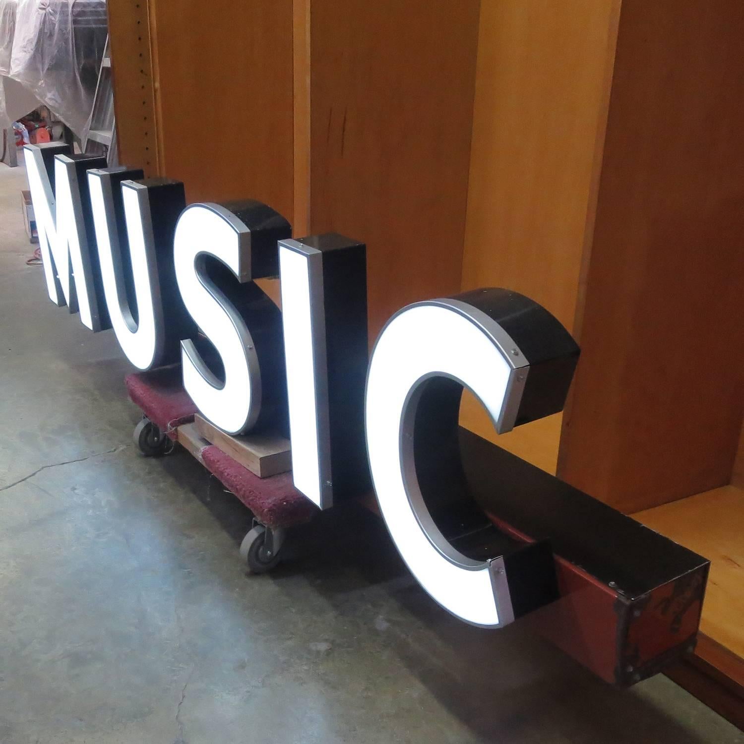 This great neon sign once graced the storefront of a music store in New York. It is impressively scaled at over eight feet in length. The raceway base is porcelain enamel over steel, while the letters are painted steel with acrylic faces over white