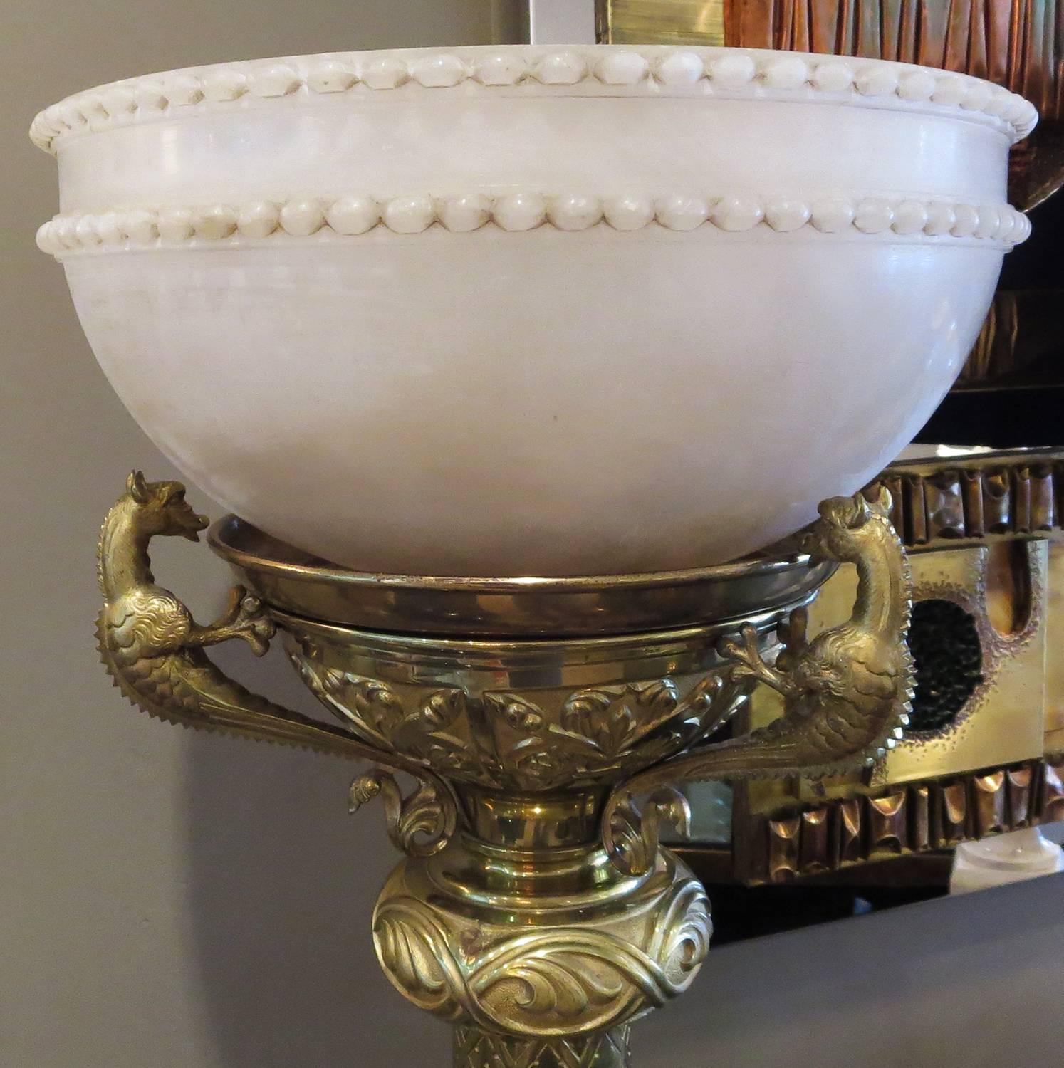 This elaborately designed lamp was most likely seen in a hotel lobby or theater foyer after the turn of the century. The body is solid and heavy, and in excellent original condition. There are three dragons surrounding the alabaster shade, and four