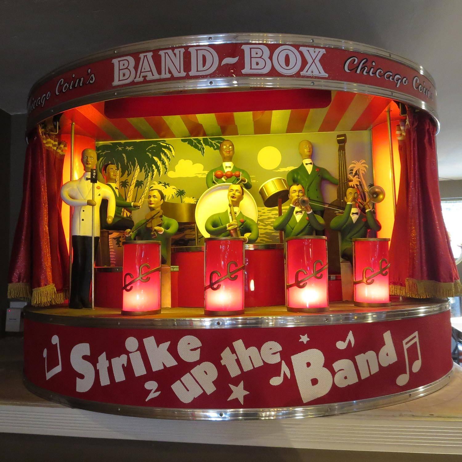 The Band Box, a mini orchestra in a cabinet, was developed to help bar owners collect more jukebox revenue. The cabinet hung on the wall, lights out and curtains closed. As soon as a song was played on the jukebox, the curtains opened, lights came