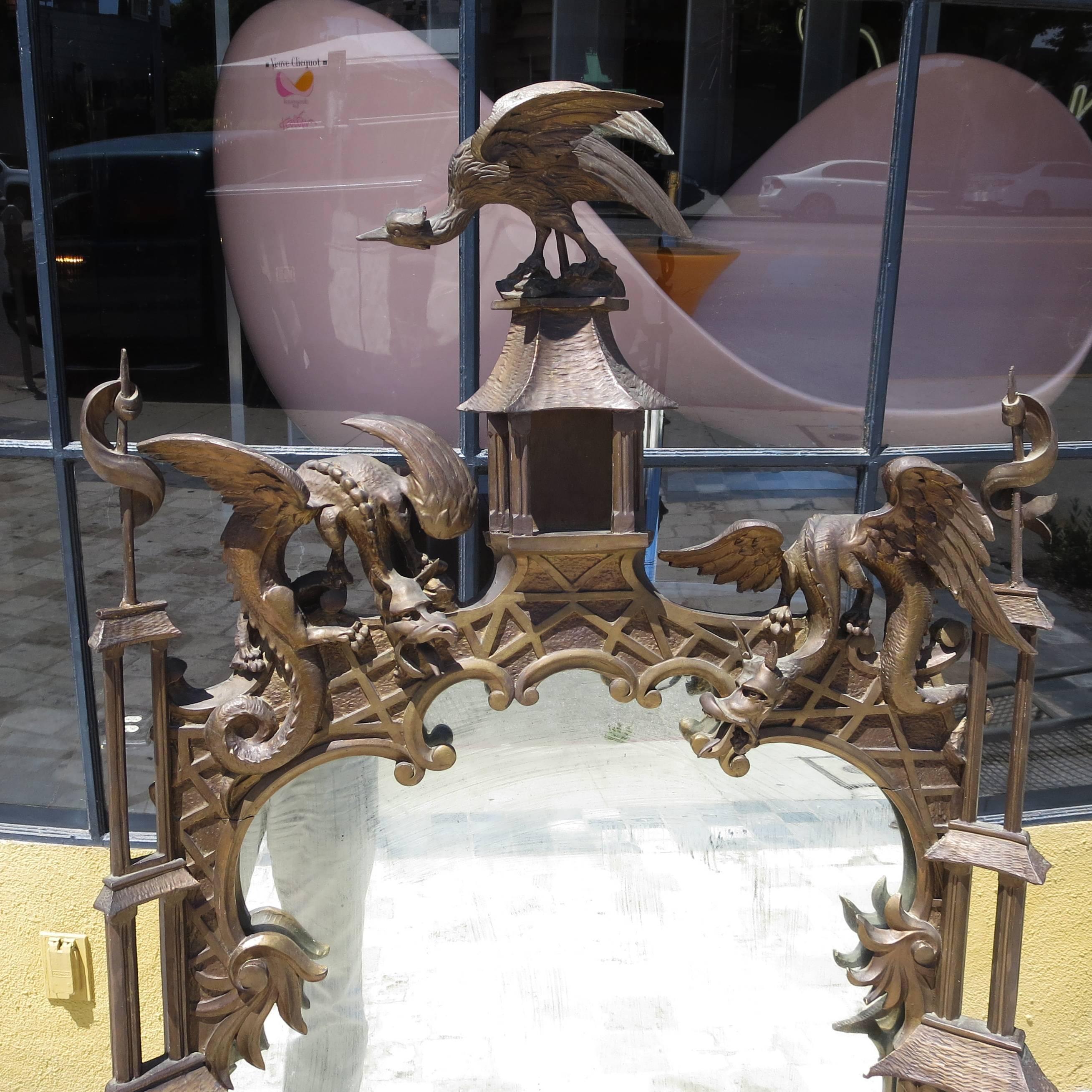 One of the best we have seen! This early 20th century mirror is finely carved with dragons, pagodas, a large bird in the centre, and a rickshaw scene at the bottom. The wood has an aged gold painted finish in good original condition. The mirror is