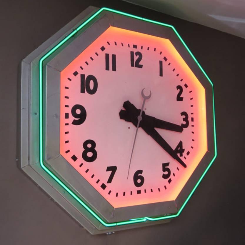 A beautiful example of moderne styling represented in this octagonal Deco neon clock. Easy to live with dark green glass forms the outside ring, the inside ring is red but hidden by the bezel so you see only the glow. There is a pull chain to turn