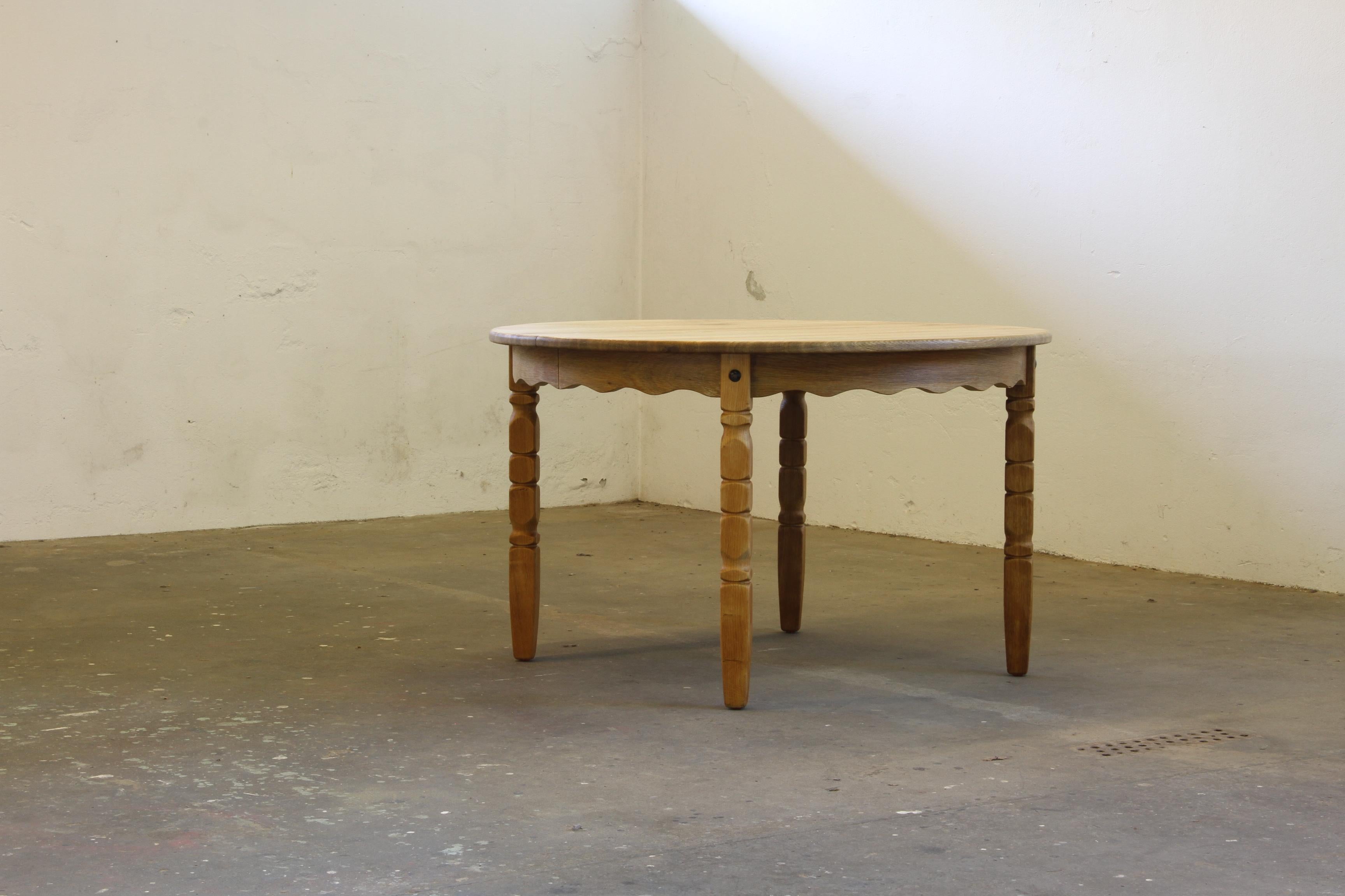 Vintage mid-century oak dining room, or kitchen, table captures the essence of Henning Kjærnulf's design philosophy, blending a bold brutalist aesthetic with refined danish craftsmanship. The intricate leg carvings harmonize beautifully with the