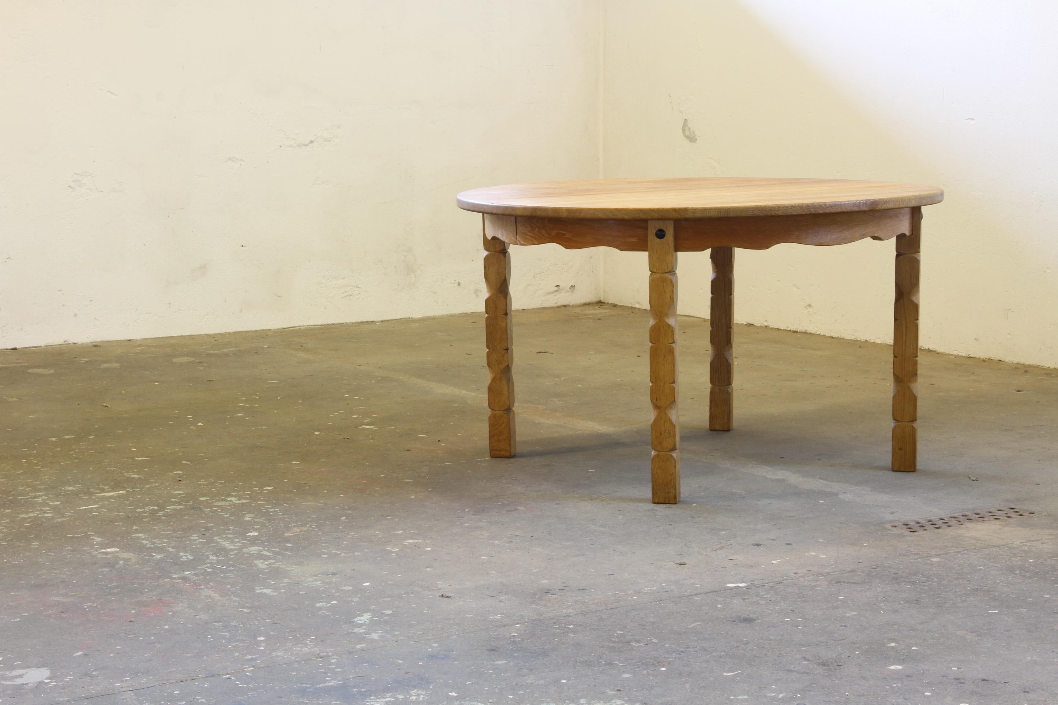 Vintage mid-century oak dining room, or kitchen, table captures the essence of Henning Kjærnulf's design philosophy, blending a bold brutalist aesthetic with refined danish craftsmanship. The intricate leg carvings harmonize beautifully with the