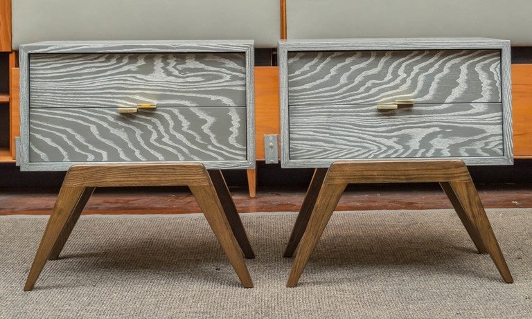Pair of stylized nightstands or end tables designed by Maximilian for Karp Furniture Co.
 Newly finished in a cerused light grey on stained splayed legs with brass pulls.