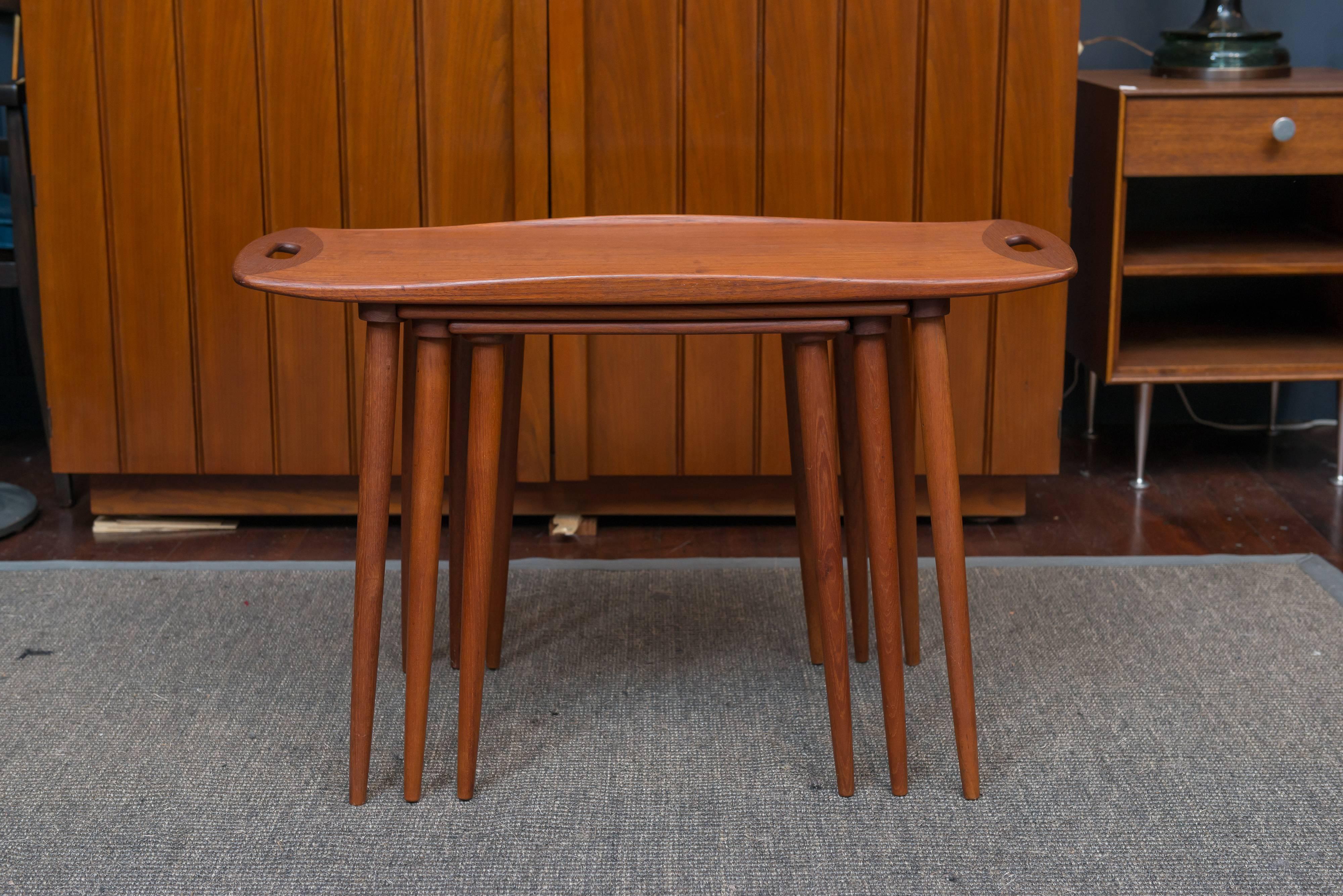 Sculptural set of three teak nesting tables designed by Jens Quistgaard for Nissen, Denmark. The top one having tray handles on tapering legs. Very good vintage condition.