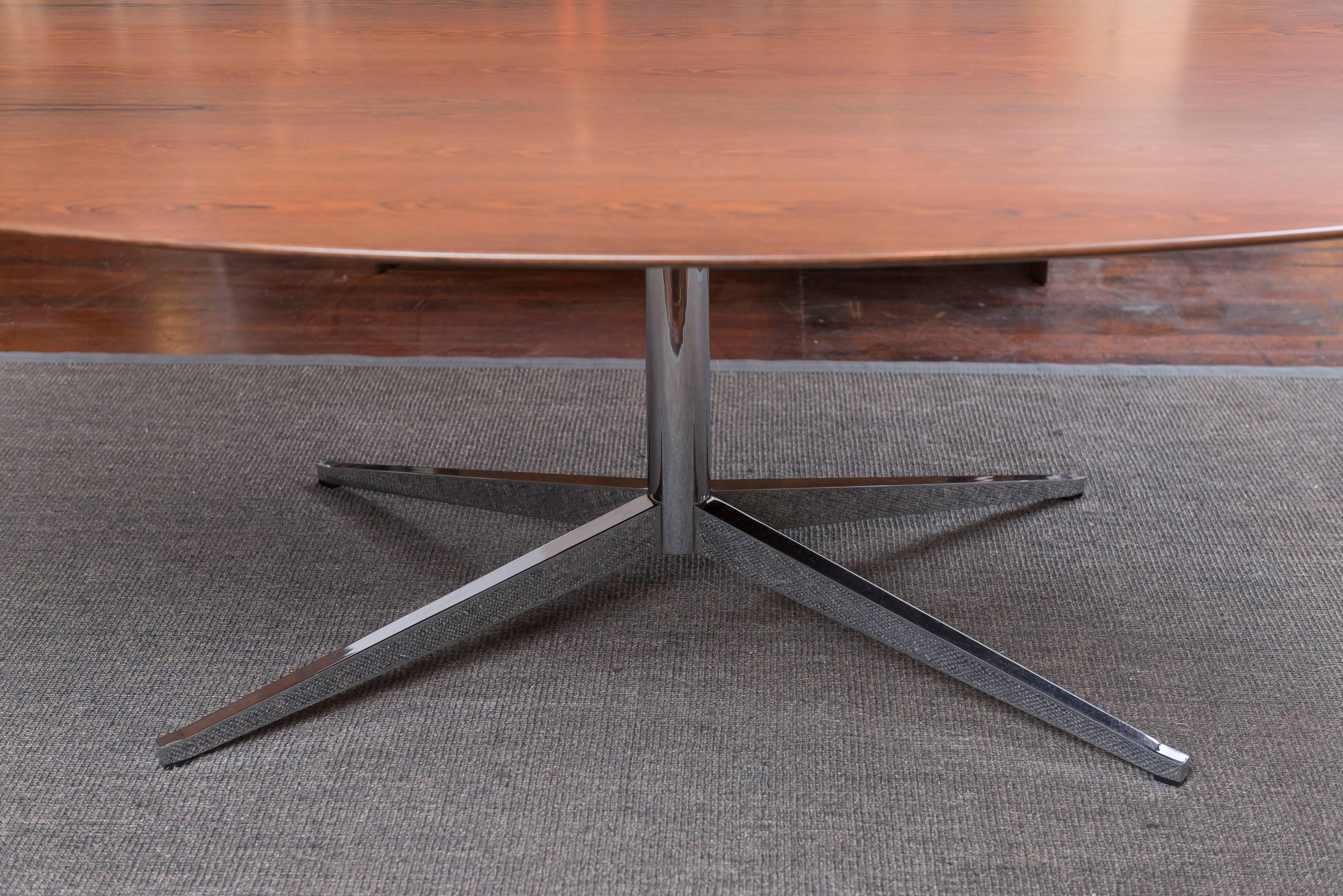 Florence Knoll design rosewood oval and chrome-plated steel dining table, manufactured by Knoll. This is the rare larger version of this table which comes with a custom riser to lift table to a standard 29