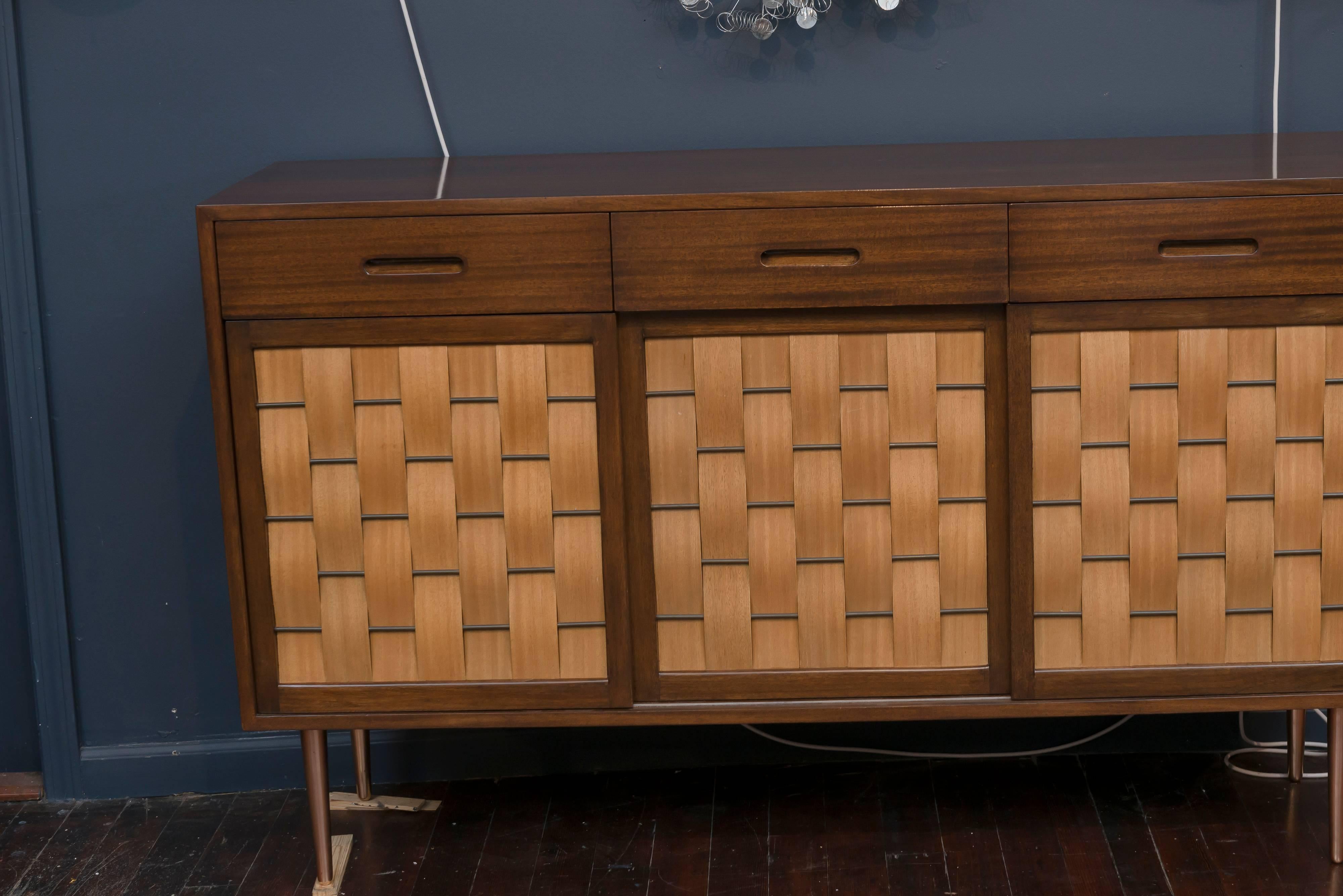 Elegant design by Edward Wormley for Dunbar Furniture Company, Berne Indiana. Perfectly refinished mahogany case with three top drawers and sliding woven front doors on tapering polished legs. Fitted interior comprises six drawers and two adjustable