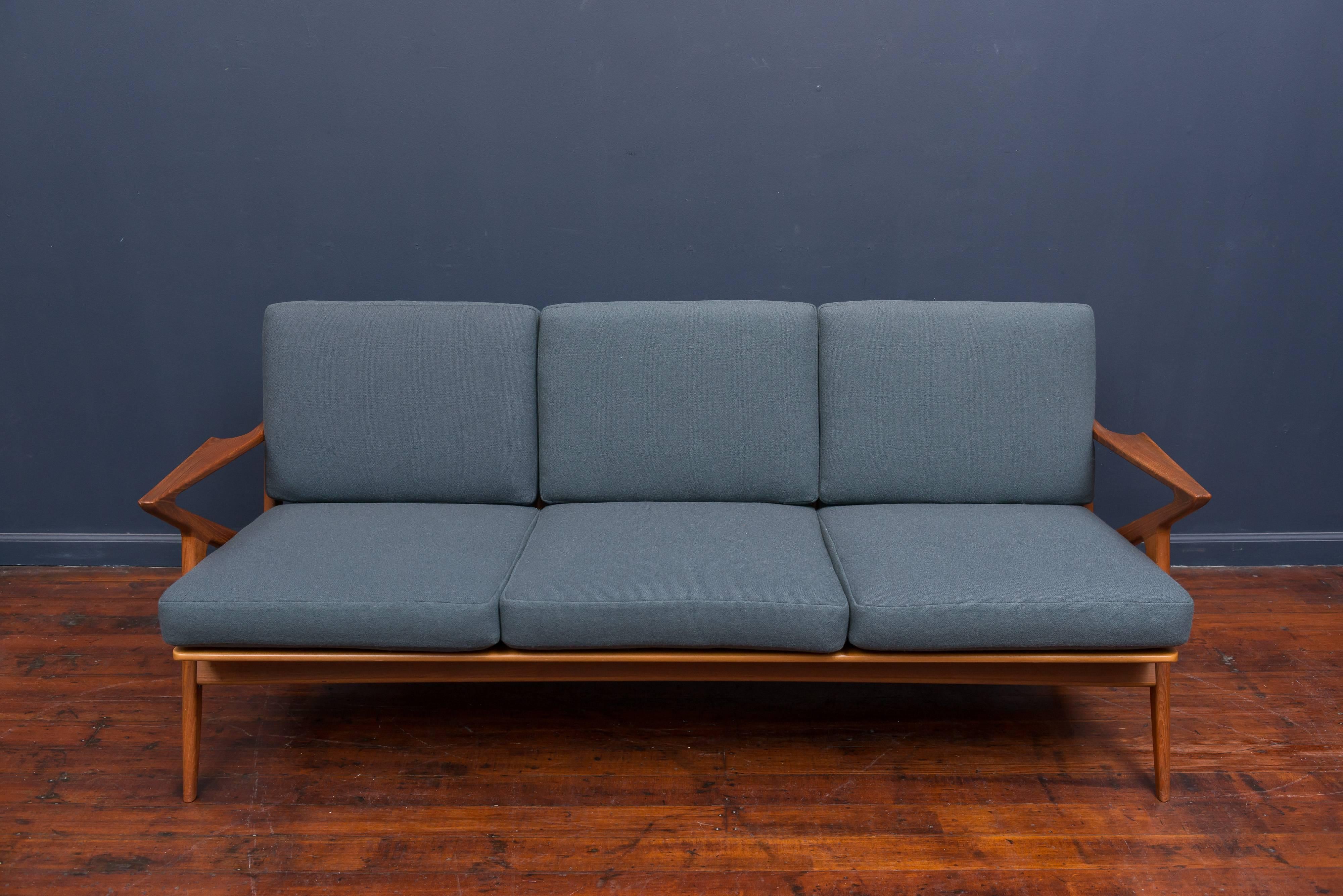 Sculptural design solid teak sofa designed by Poul Jensen for Selig, Denmark. All new foam cushions in a beautiful teal wool with new straps, stamped.
      