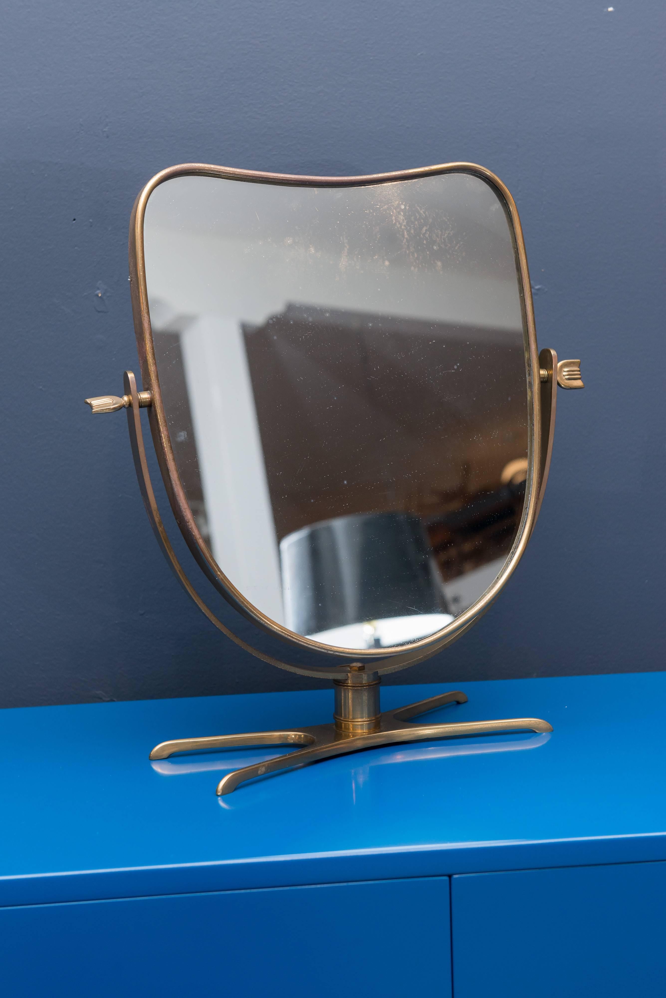 Italian brass pivoting vanity mirror with arrow motif fittings, Italy.