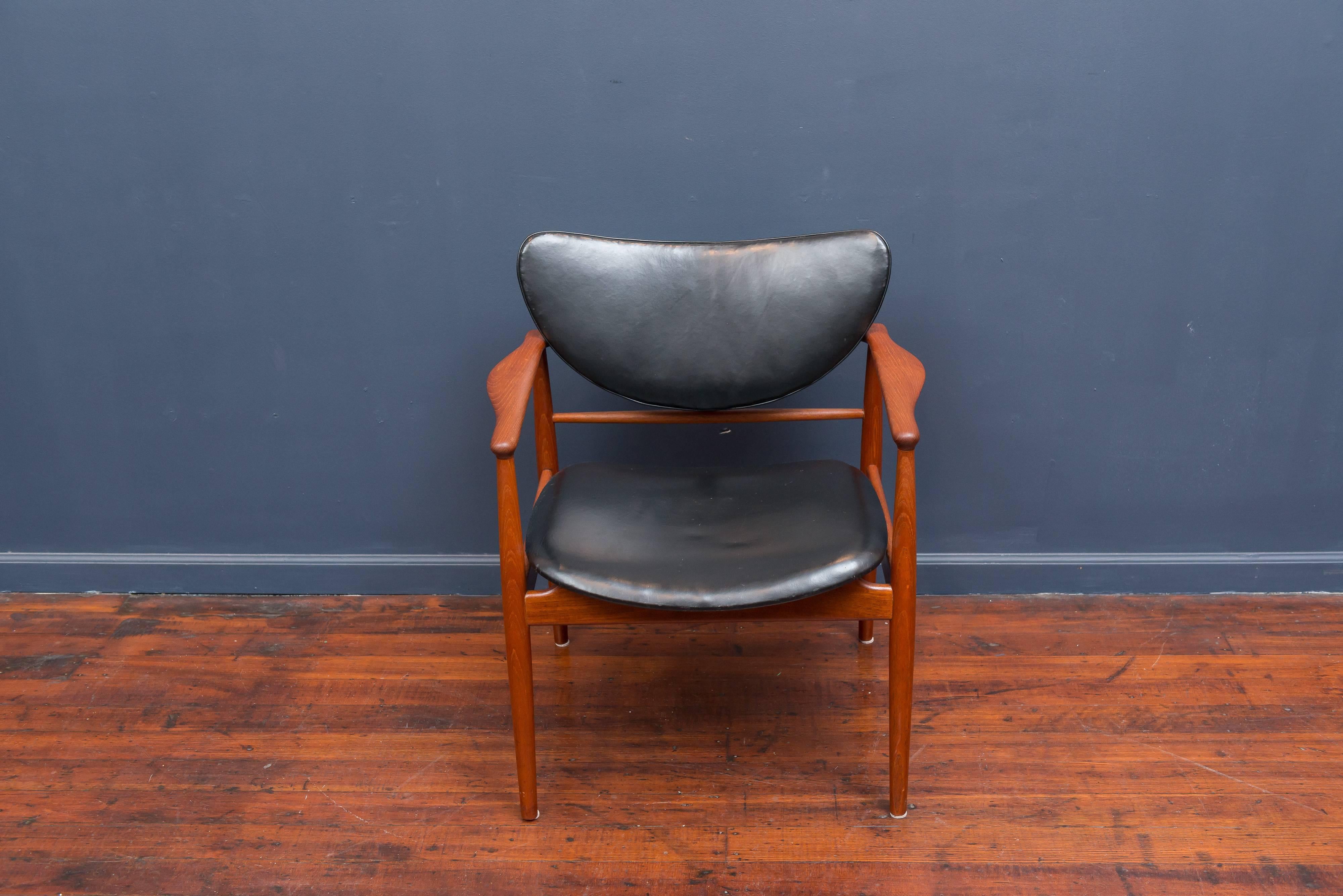 Finn Juhl model NV 48 armchair for Niels Vodder, with embossed maker's stamp to the rear stretcher. Good condition black leather upholstery with a refinished teak wood frame, three dots or dowels appear on one back side stretchers. 