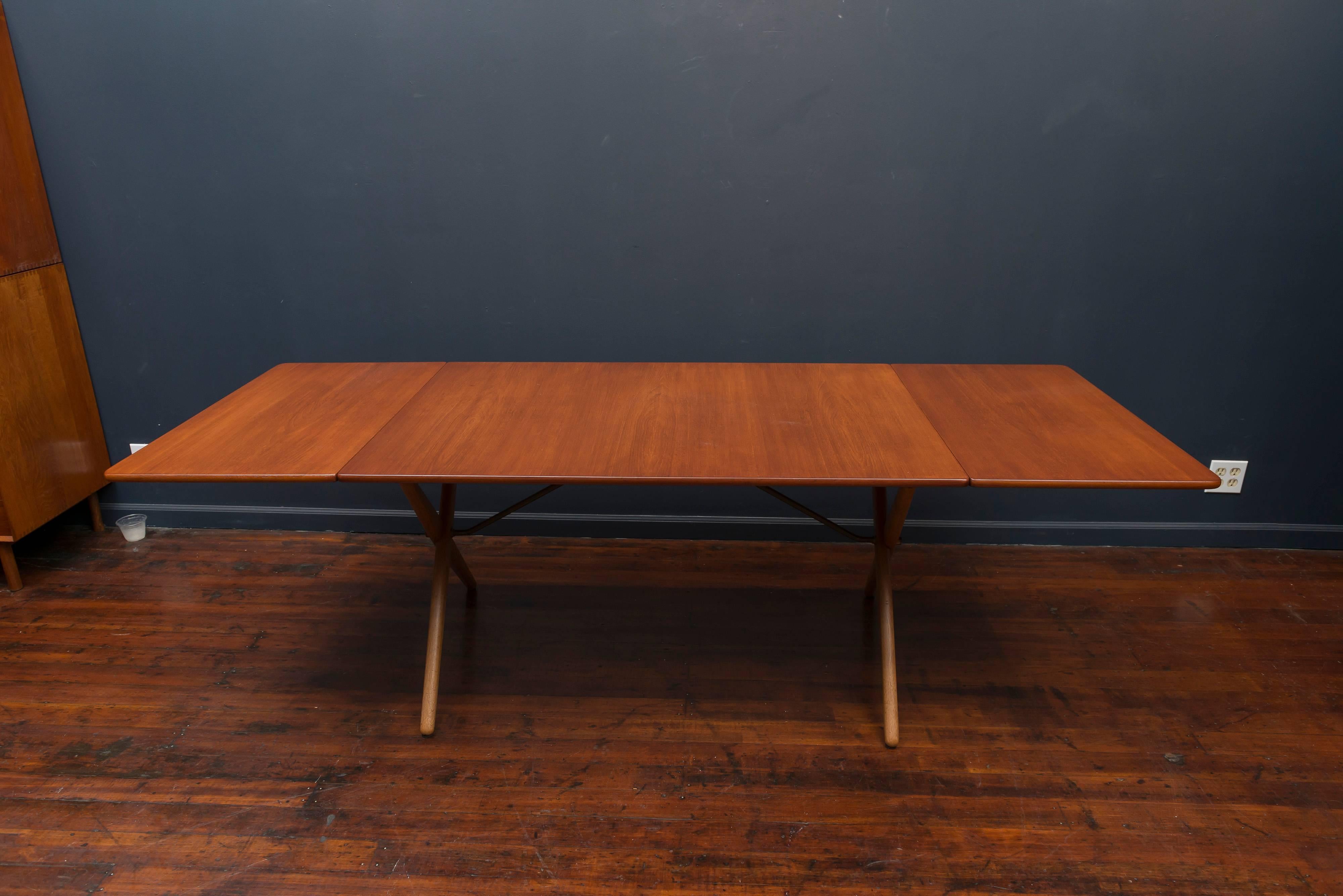 Hans Wegner design drop leaf dining table for Andreas Tuck, Denmark. Perfectly refinished teak top and leaves on a solid oak X-base with architectural brass supports, signed.
Fully open width is 89.75 inches.