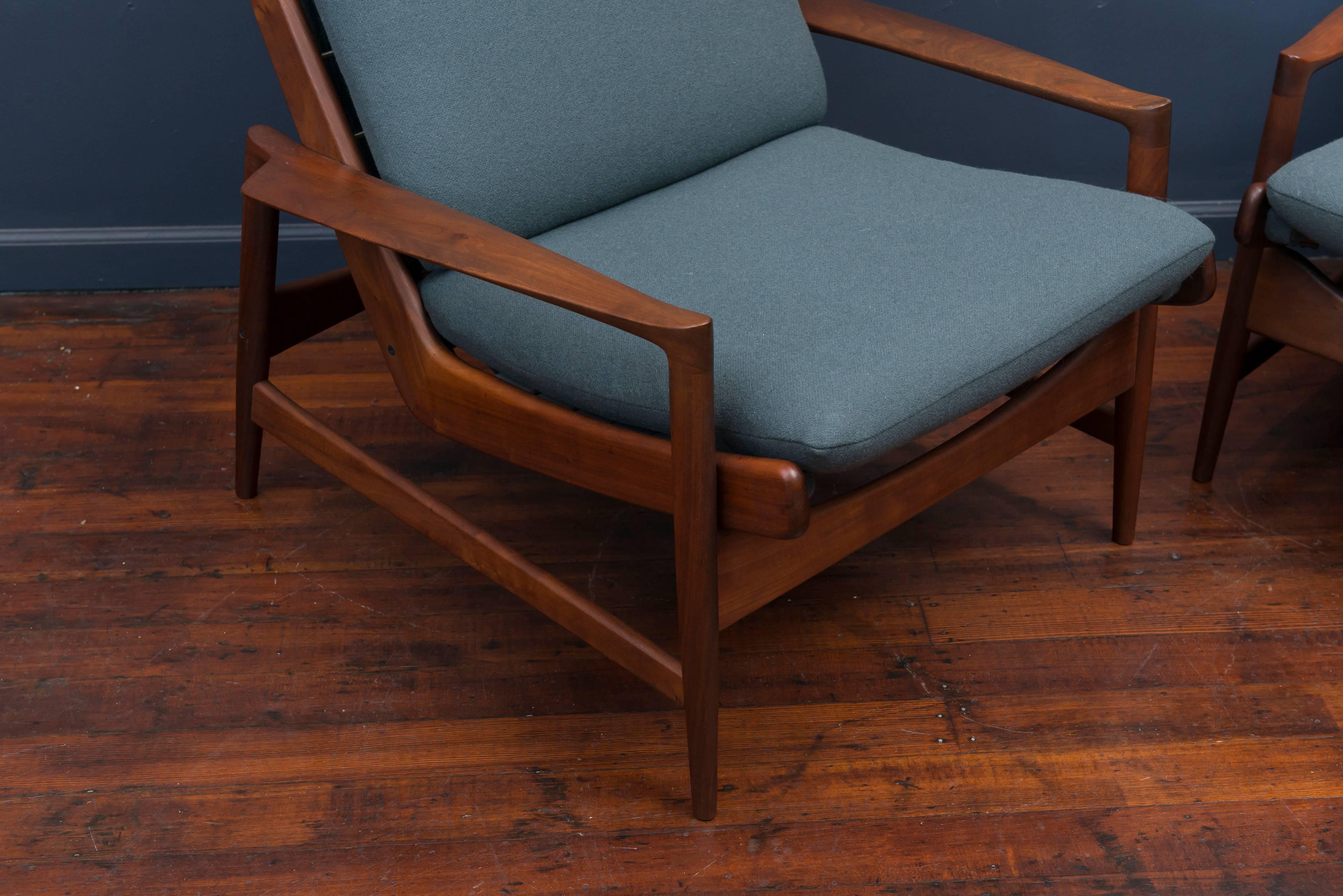 Fantastic pair of Ib Kofod-Larsen design high back lounge chairs. Perfectly upholstered in a deep teal wool and oiled teak frames.