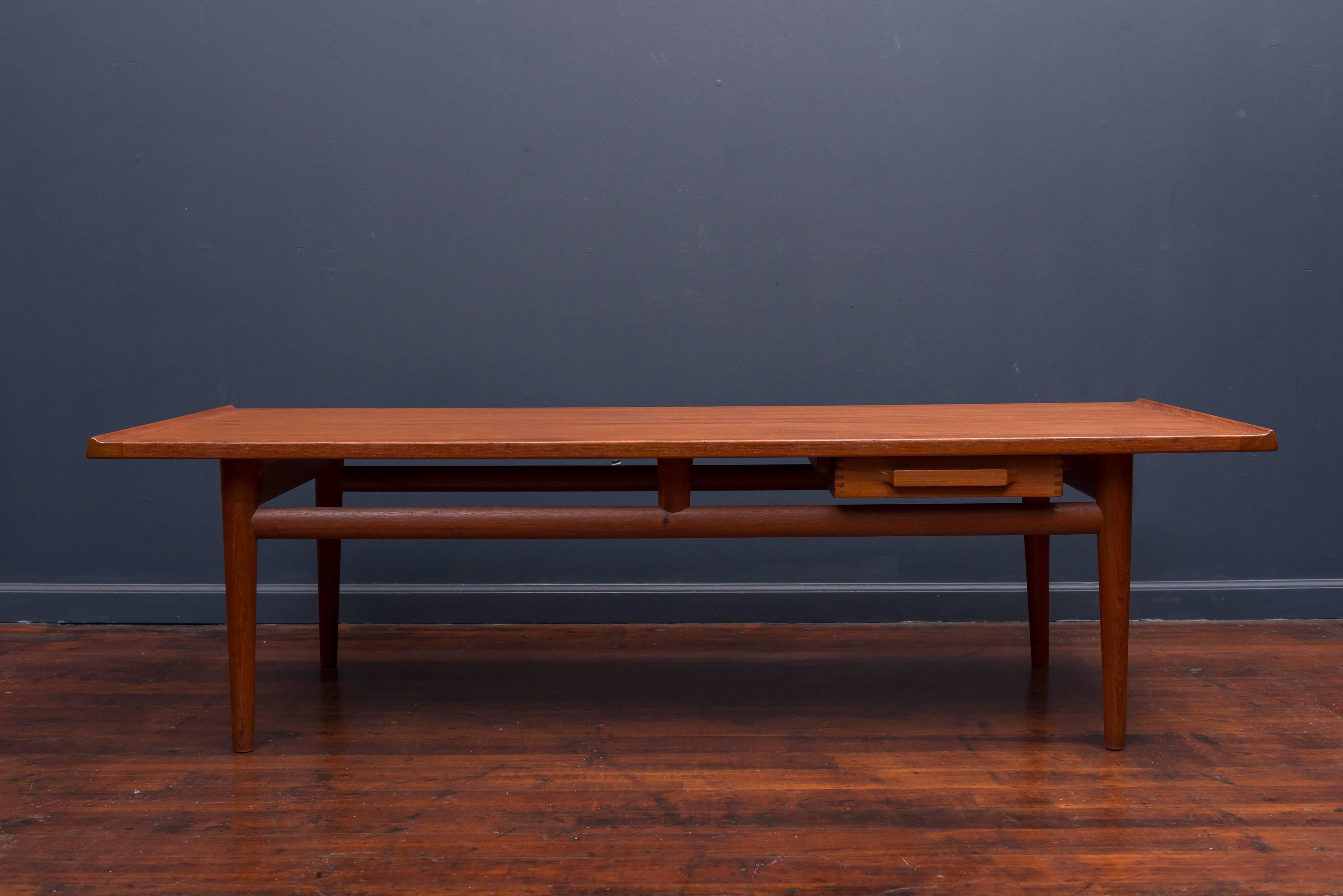 Large Danish modern coffee table made from teak with a two way sliding single drawer. Excellent original condition and construction.