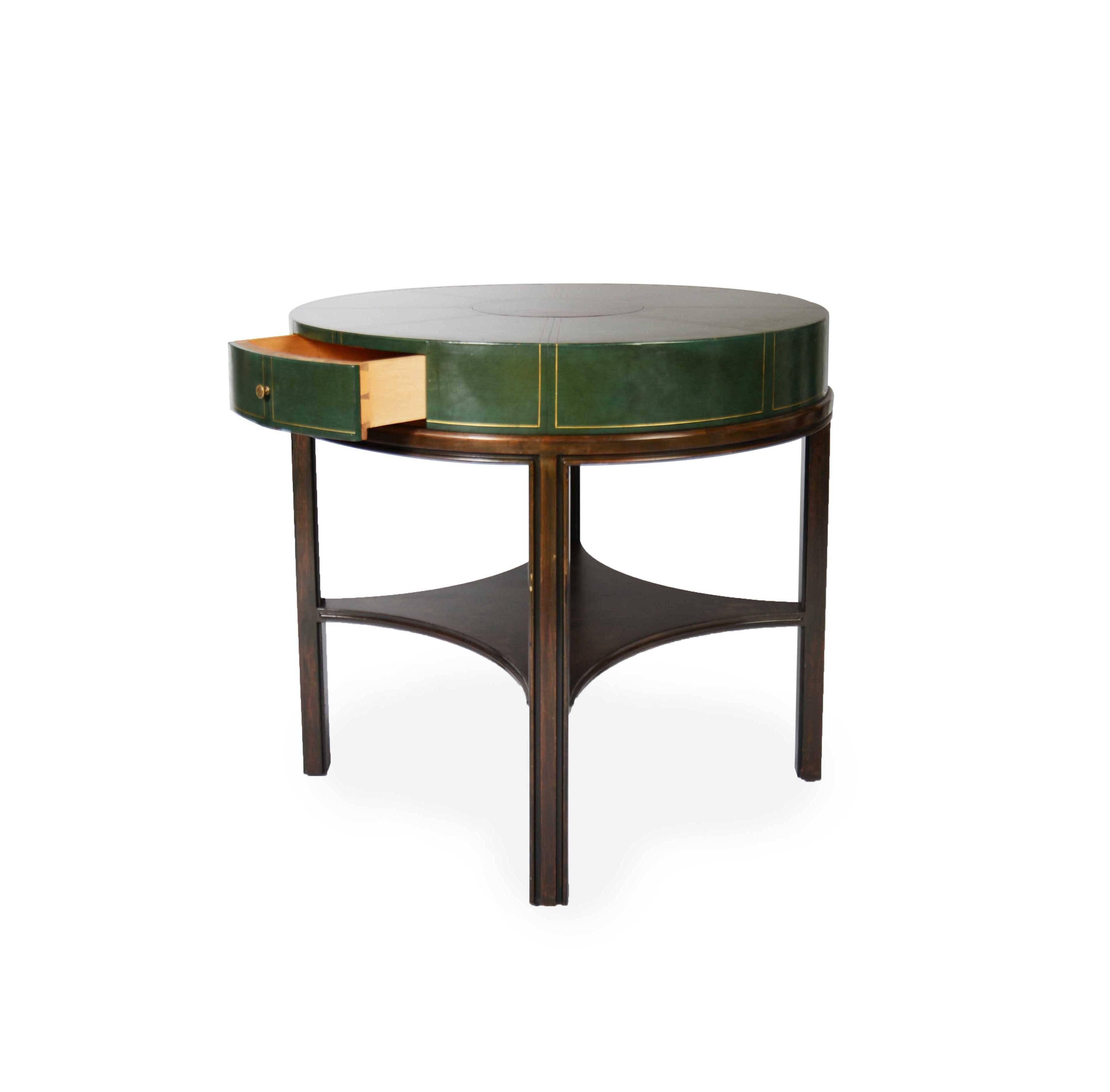 Gold embossed green leather top with small dovetail drawer on a channeled mahogany base produced by Charak.