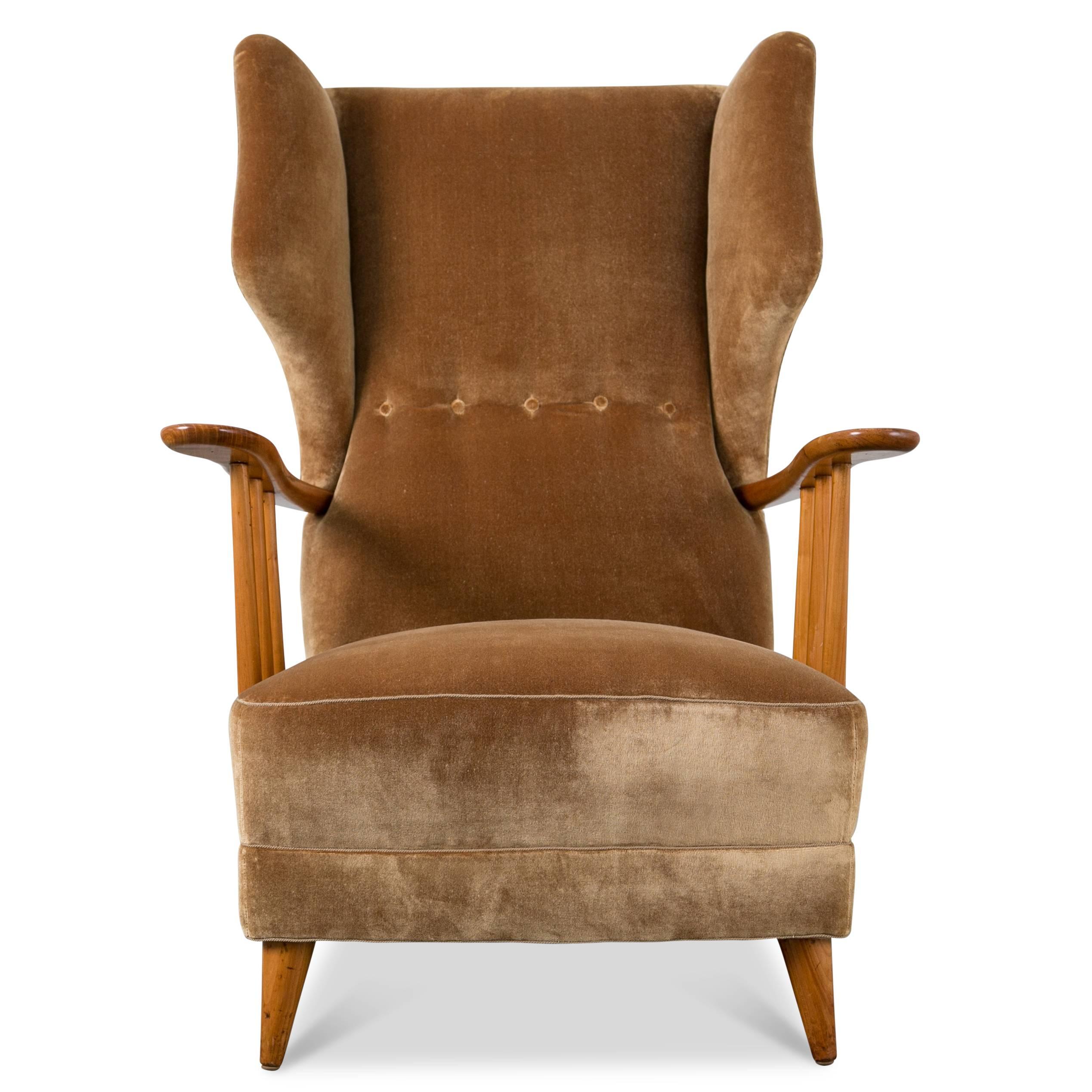 Modernist wingback lounge chair with walnut frame. Upholstered in gold silk velvet.